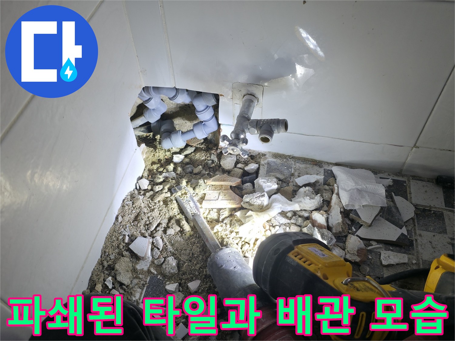 드릴 작업 후 드러난 벽면 배관과 흩어진 타일 조각들입니다.