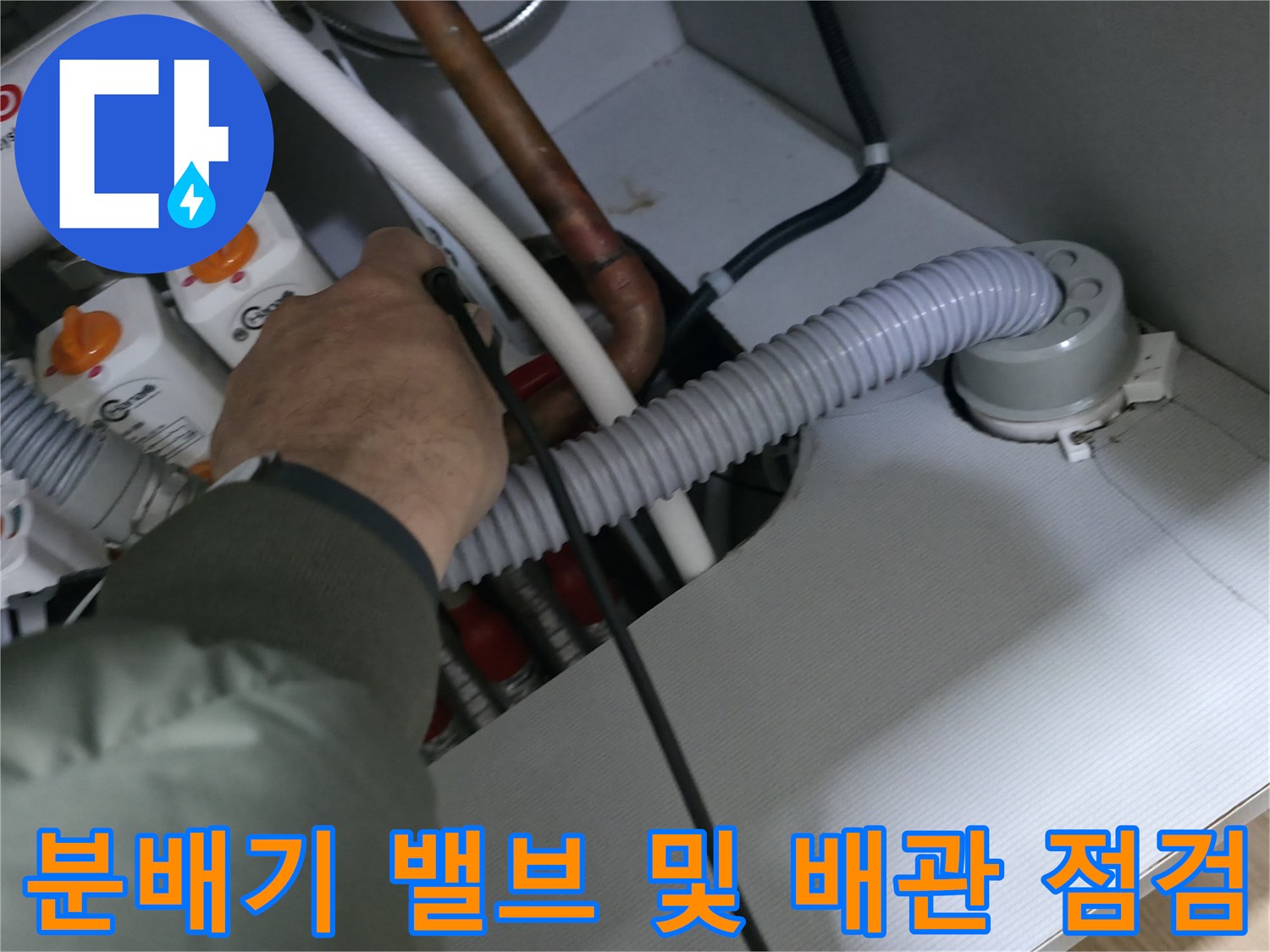 난방 배관의 연결 부위와 분배기 밸브를 세밀하게 확인하고 있습니다.