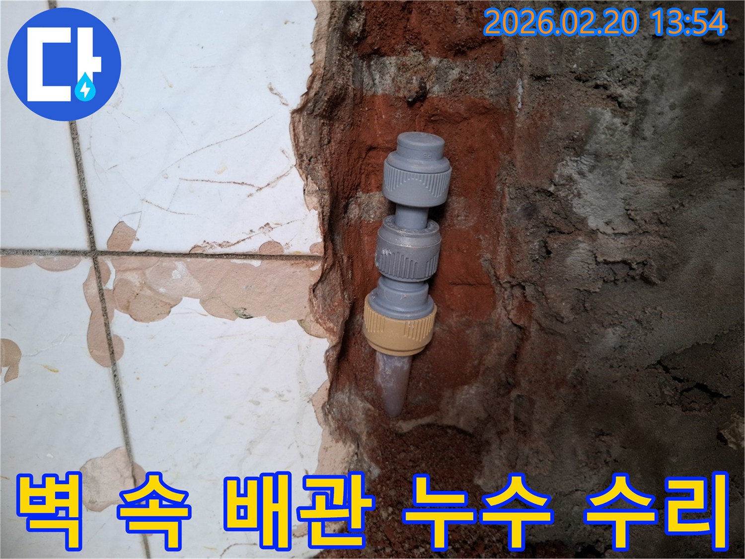 벽을 개방하여-드러난-수도배관의-누수 지점을-새로운 연결 부품으로-수리하는-작업 현장입니다.