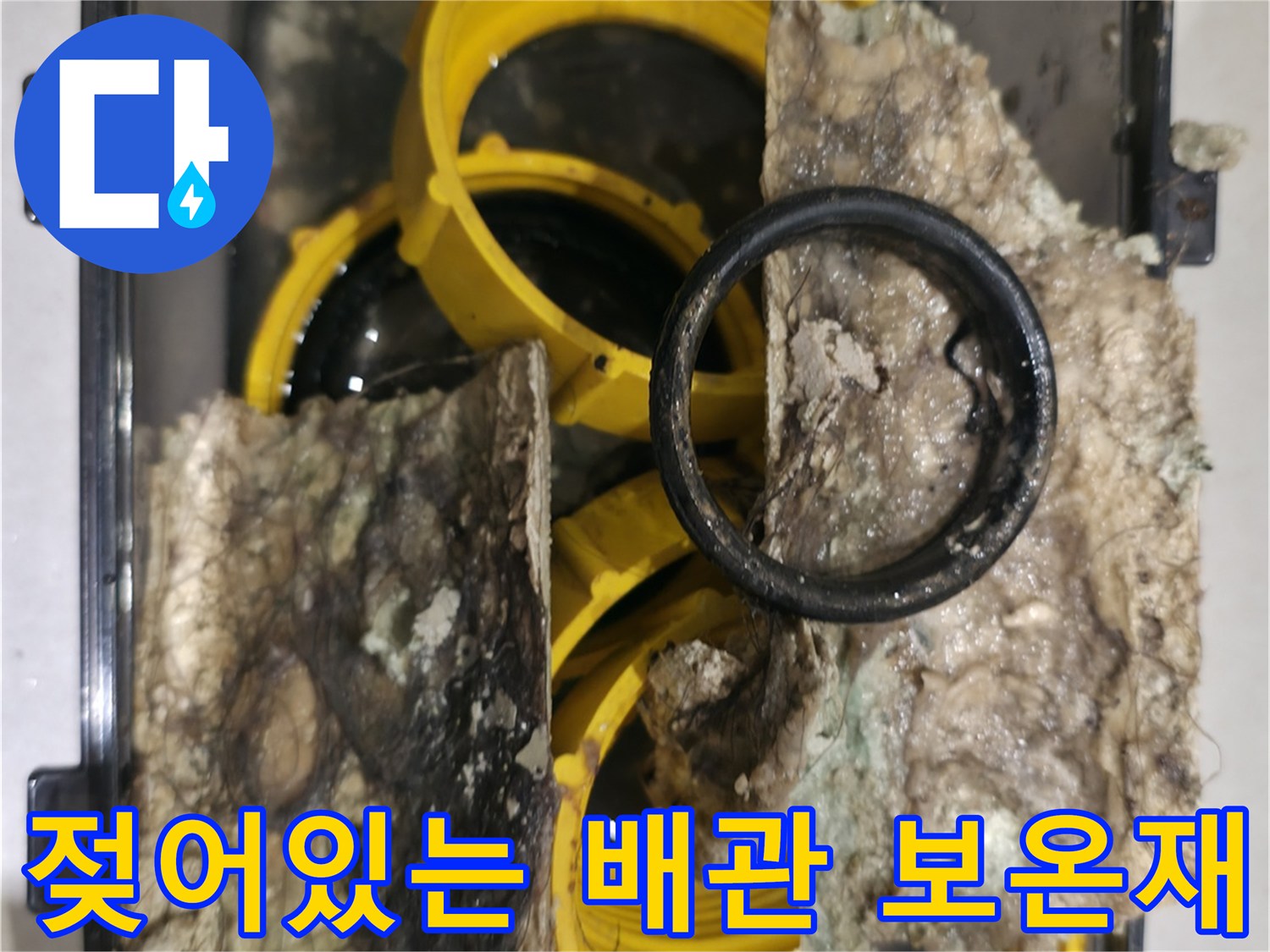 배관 누수로 인해 검게 변한 유리섬유 보온재 부위