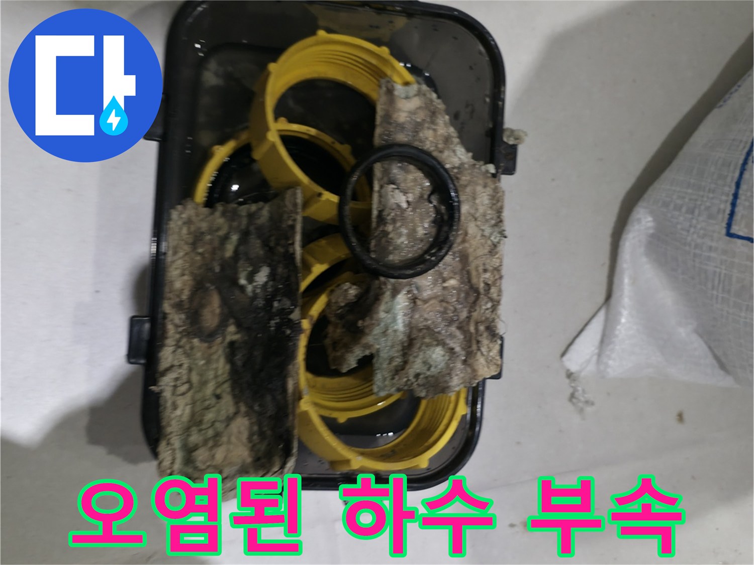 슬러지가 뭉쳐 있는 노후된 하수 배관 연결부 사진입니다.