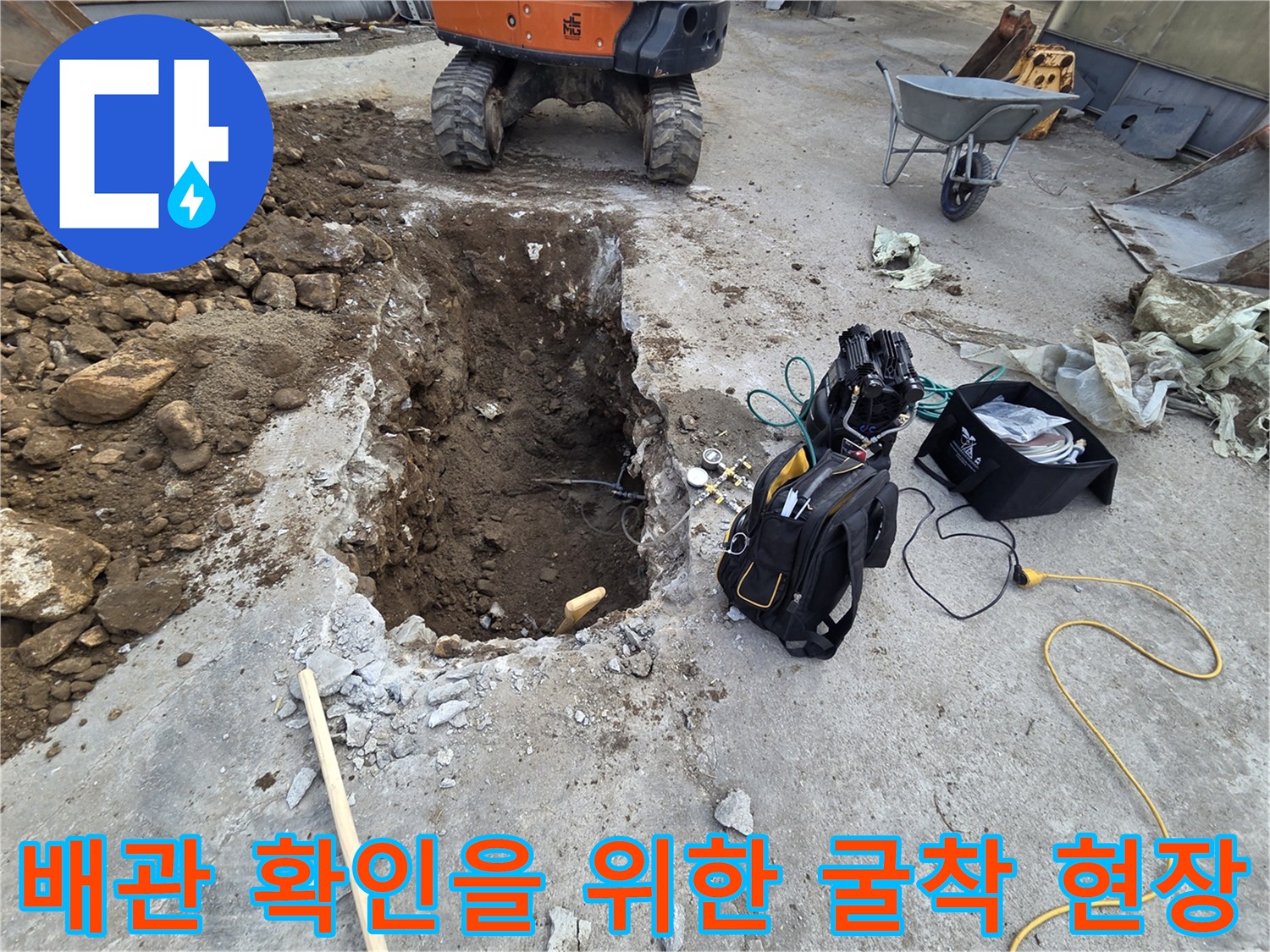 미니 굴착기로 콘크리트를 파쇄하고 흙을 걷어낸 배관 노출 부위