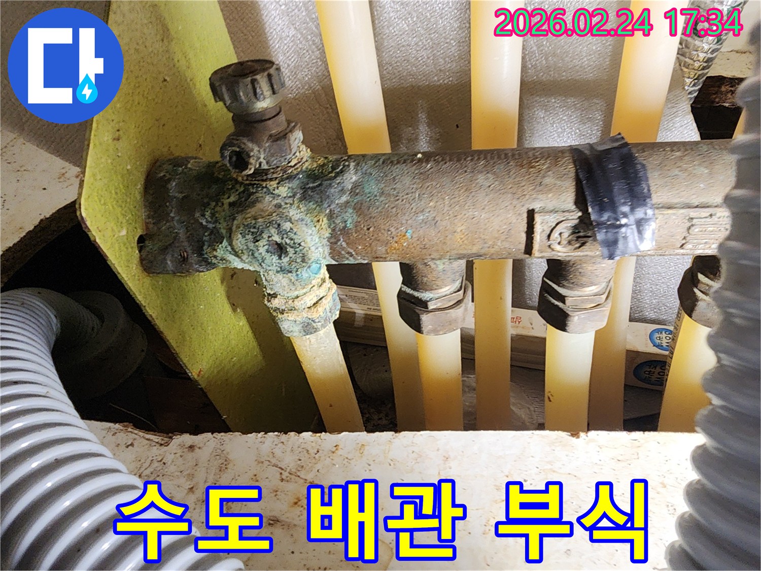 이 이미지는 오래된 주택의 수도 배관 분배기에서-발견된 심각한 부식과-그로 인한 누수 흔적을 상세히 보여줍니다.