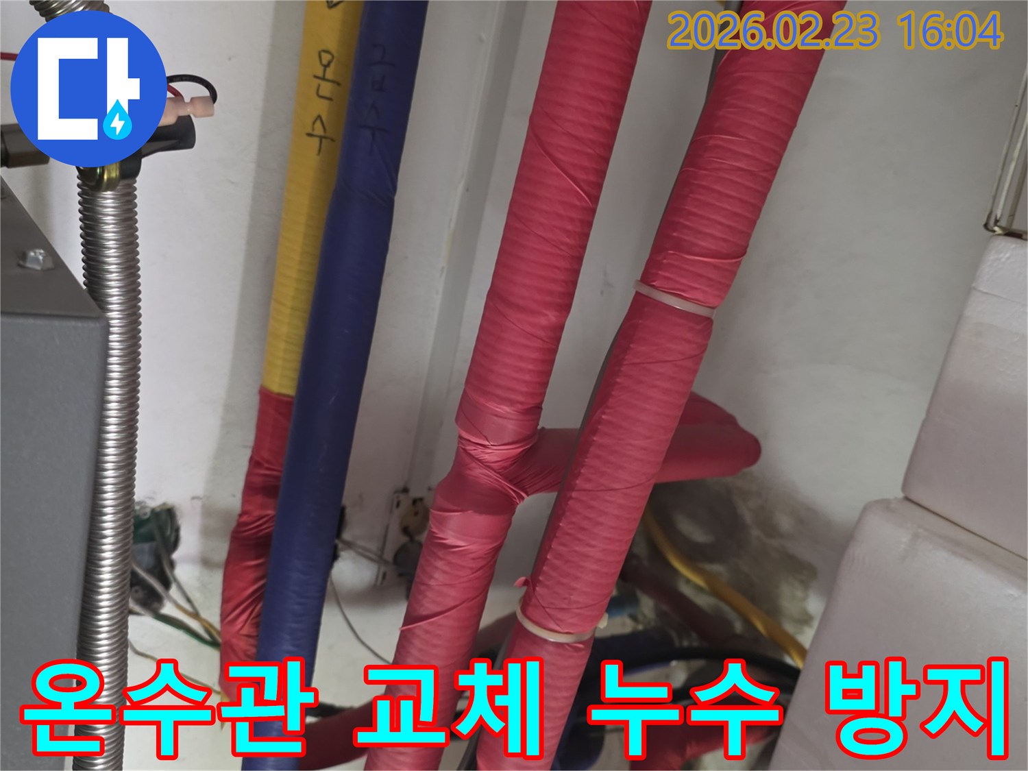 붉은색 단열재로 감싸진 온수 배관의 모습-누수 재발 방지를 위한 온수관 교체 및 효율 증대