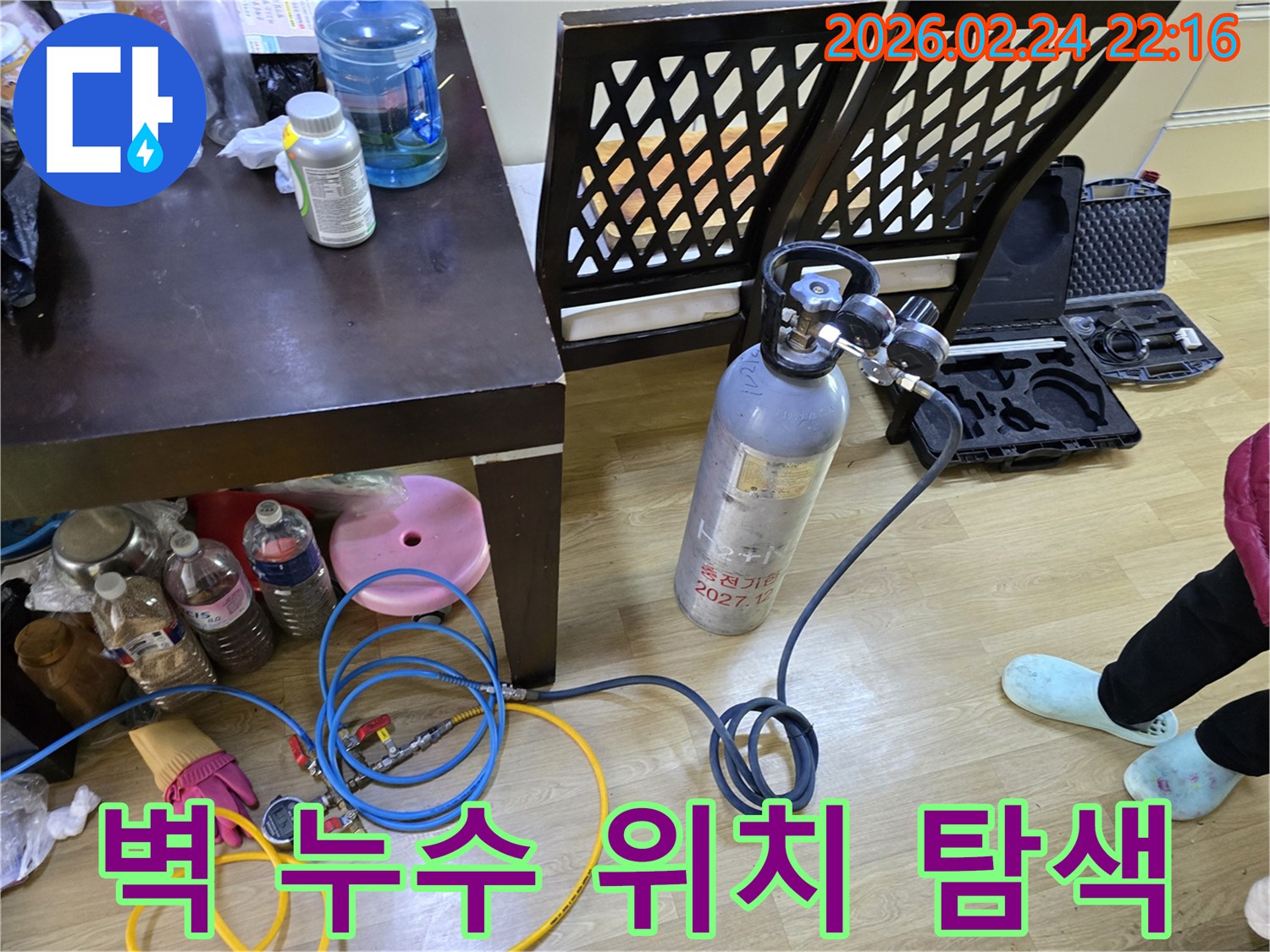 벽 내부의 누수 지점을 정확히 찾기 위해-가스통과 압력 게이지를 연결하여-탐지 장비를 세팅하는 모습입니다
