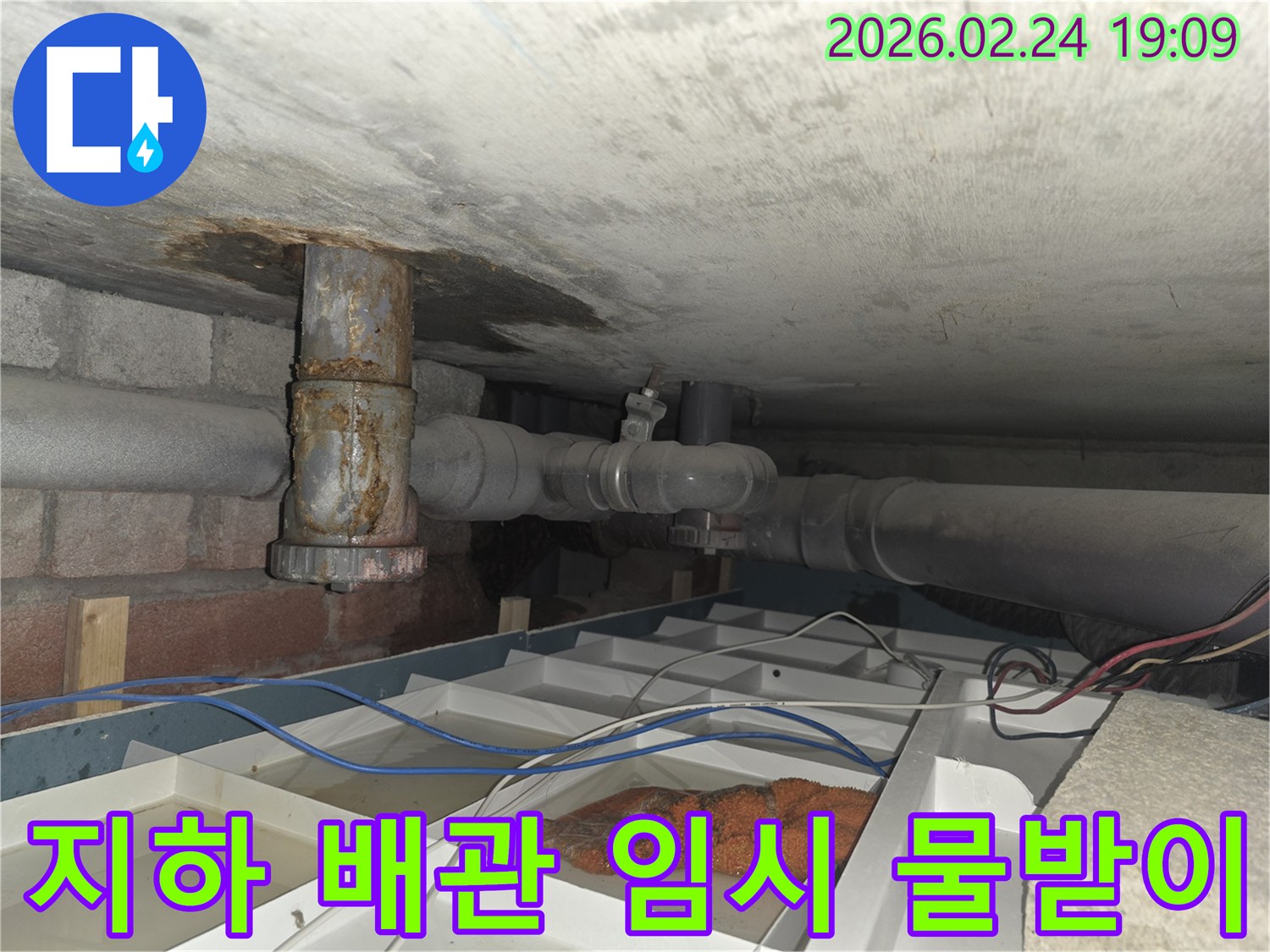 오래된 배관에서-물이 새어 나와-임시 물받이에-고인 물과 함께-보이는 현장