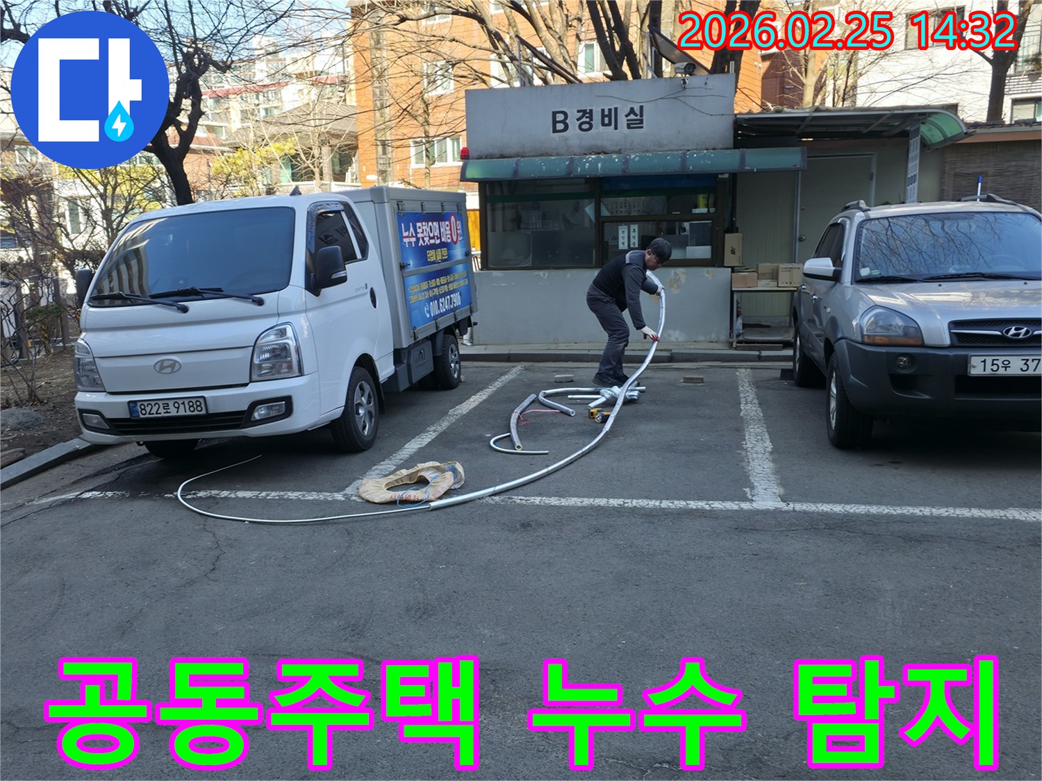 누수 전문 엔지니어가 공동주택 경비실 앞에서-누수 탐지 장비를 준비하며-정확한 원인 파악을 위해 노력하고 있습니다.