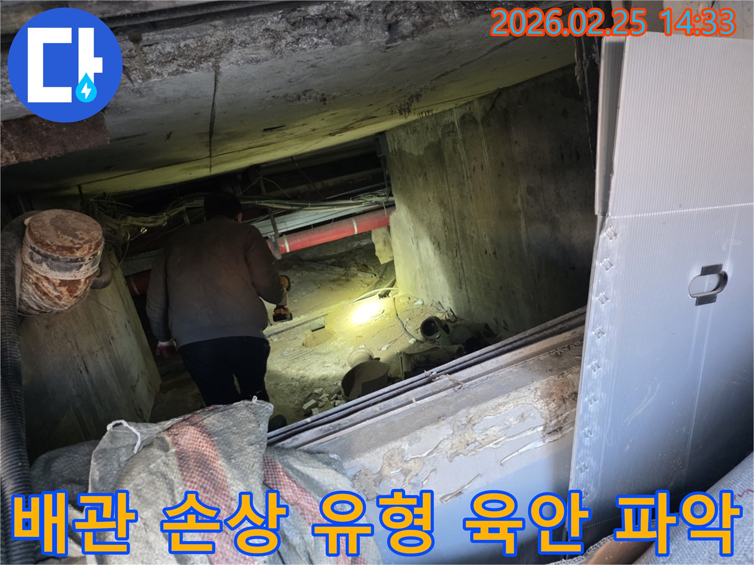 누수 전문 엔지니어가-어두운 공간에서-손전등을 비춰가며-배관의 미세한 손상 유형을-육안으로 정밀하게-확인하는 중요한 장면입니다.
