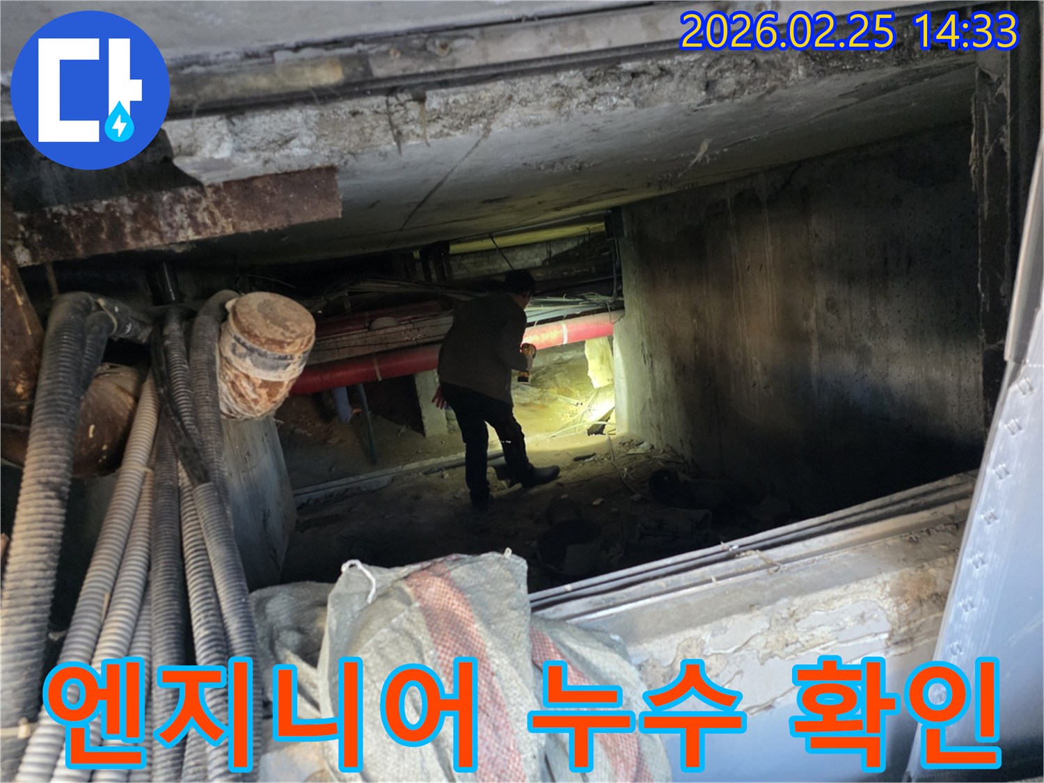 손전등을 든-누수 전문가가-복잡한 배관 사이에서-누수 지점을-확인하는 중
