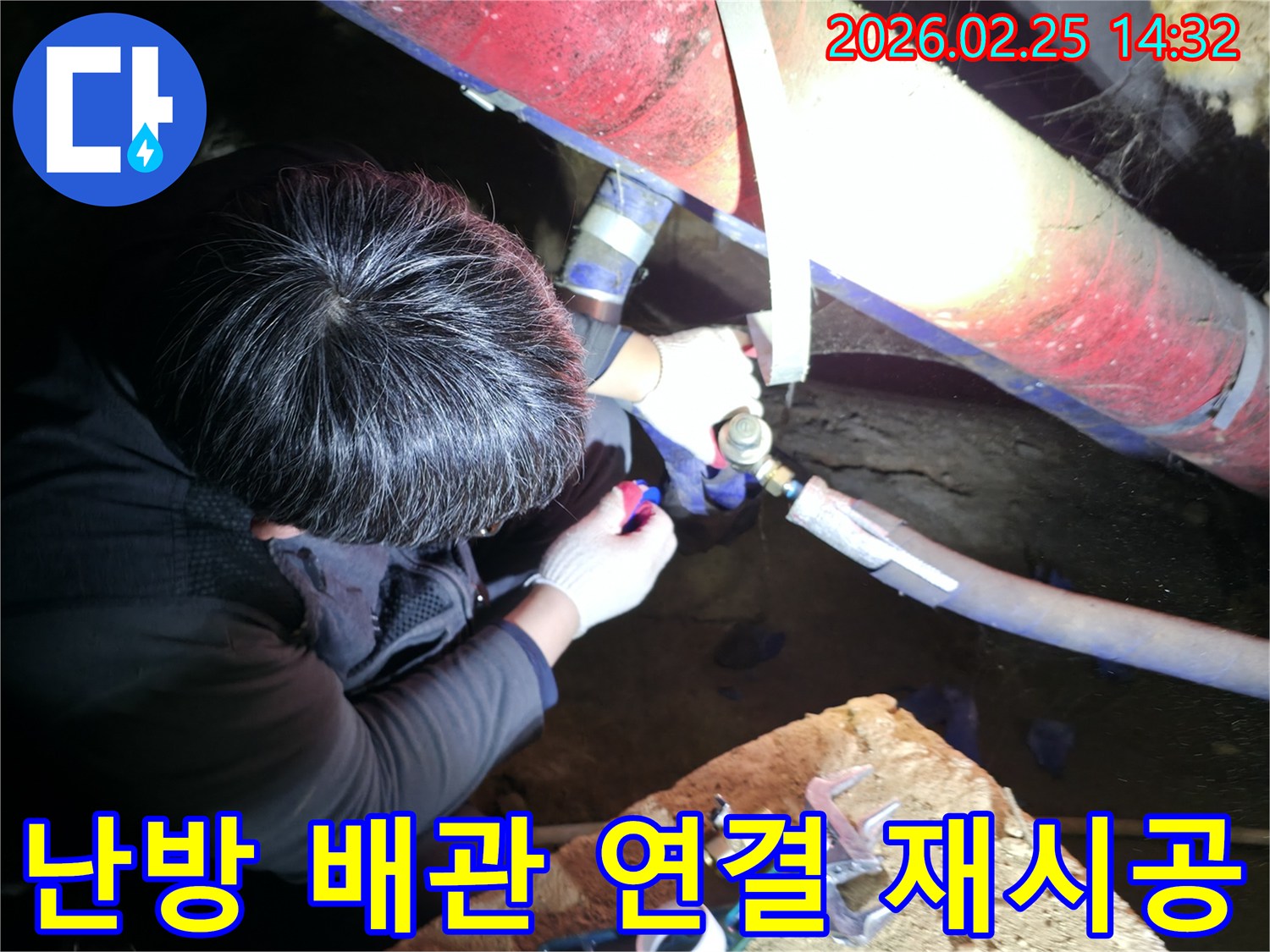 숙련된 누수 기술자가 좁은 공간에서 손전등을 비추며 난방-배관 연결 부위를 정밀하게 점검하고-꼼꼼하게 재시공하고 있습니다-난방누수해결-전문가보수