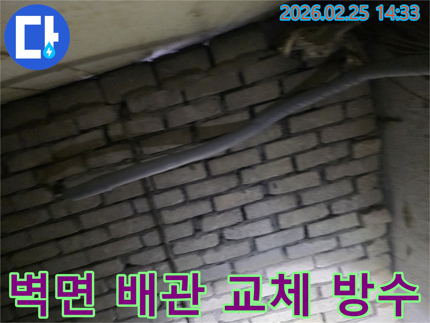 어두운 벽돌 벽면을 배경으로-낡은 배관을 교체하고-방수 작업을 준비하는-현장 공사 모습입니다.