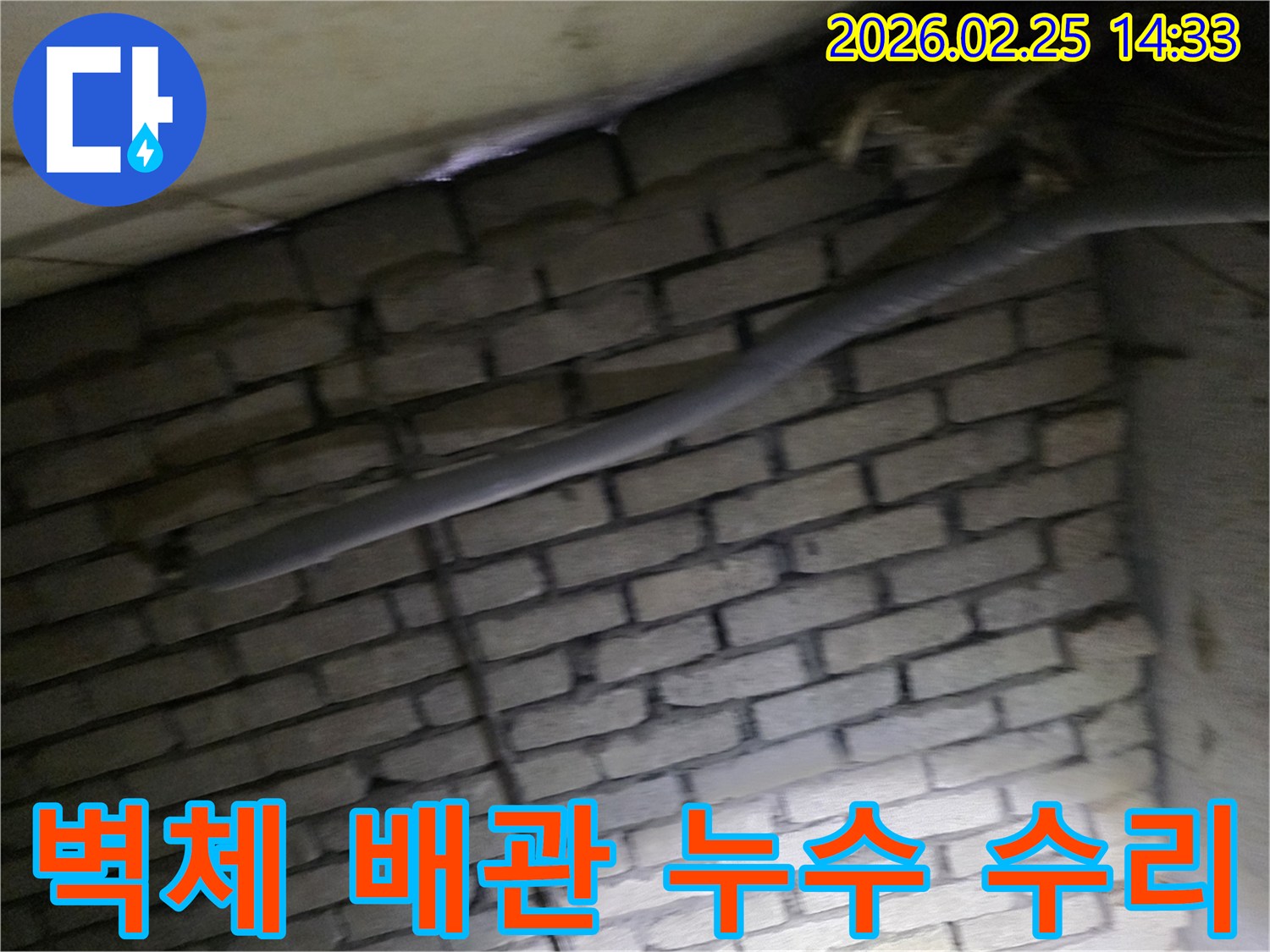 어두운 벽돌 벽면을 배경으로-단열된 배관과 함께-누수 지점을 탐지하고-수리하기 위해 검사되는 현장 모습입니다.