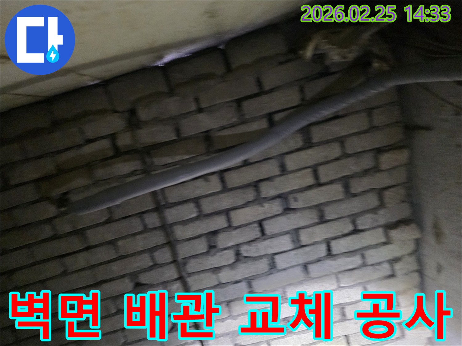 어두운 벽돌 벽면을 배경으로-단열재로 감싸인 배관을-교체하기 위해 촬영된 현장 이미지입니다.