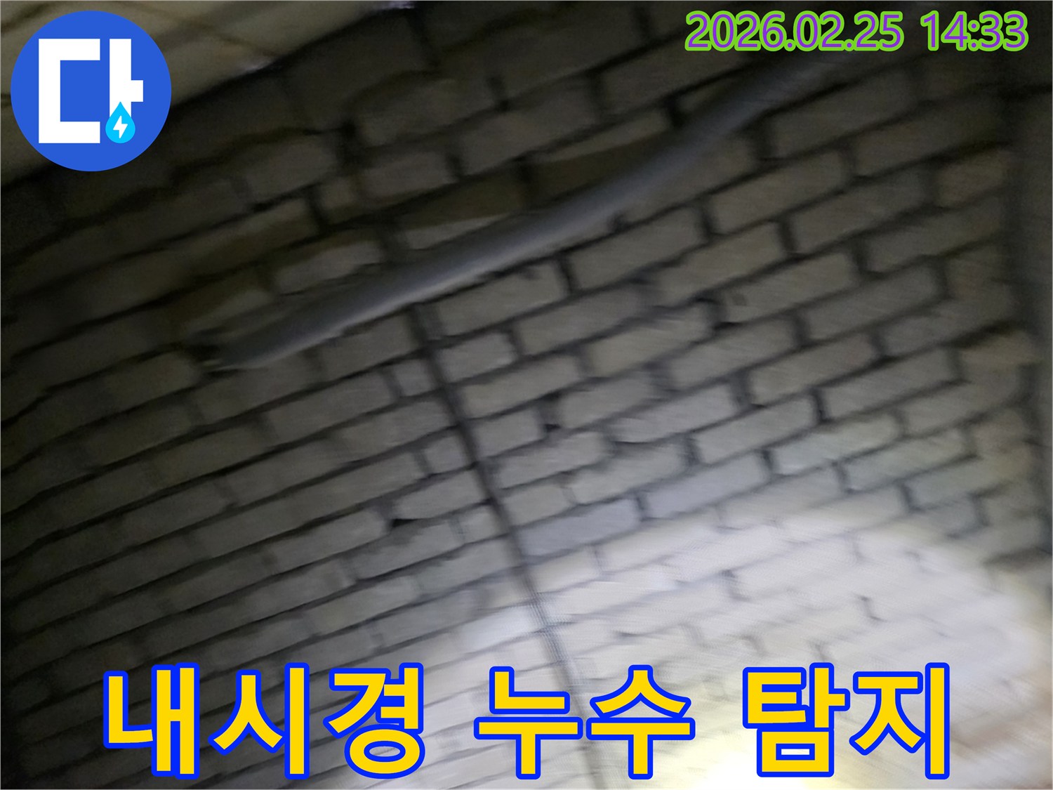 어두운-벽돌벽-내부의-좁고-깊은-곳에-숨겨진-배관-누수를-내시경-보어스코프를-이용하여-정확히-탐지하는-전문가의-모습