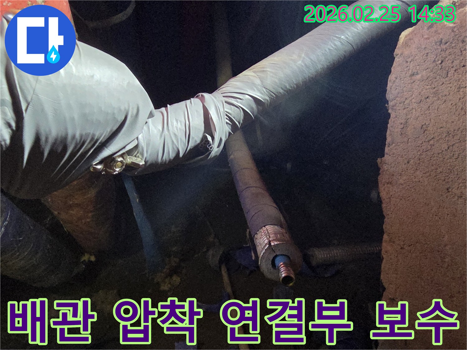 어두운 작업 공간에서-장갑을 낀 손이-배관의 압착 연결부를-단단히 조여-누수를 밀봉하는-모습입니다