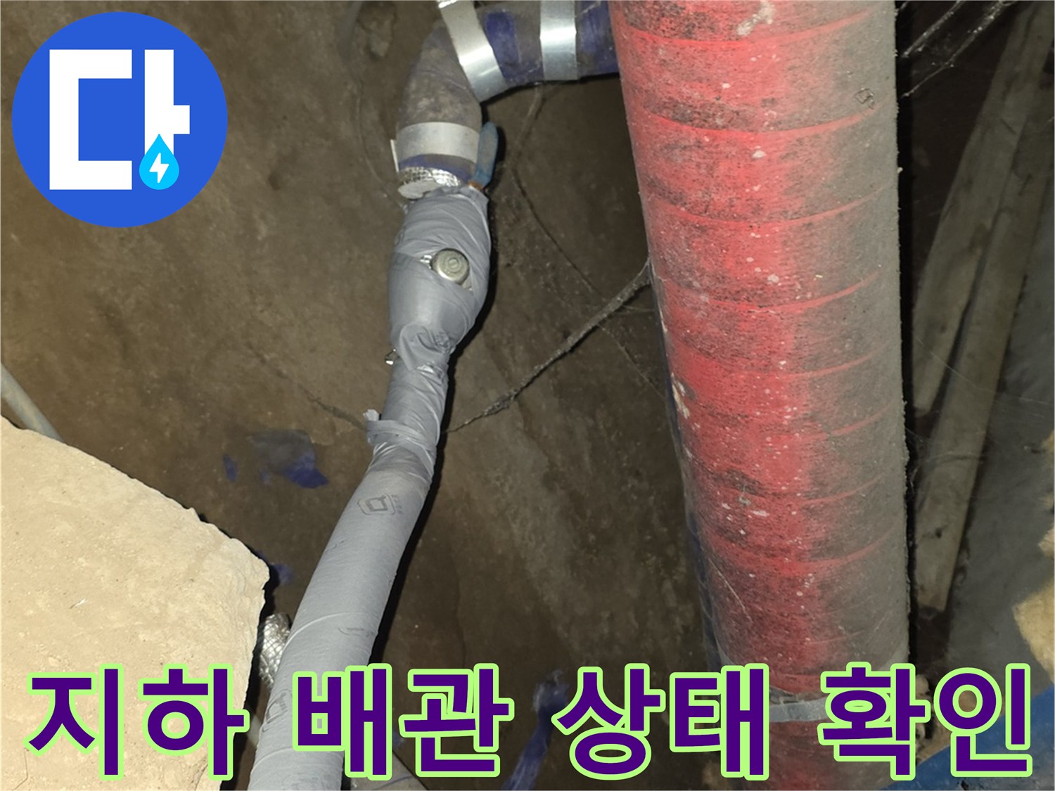 지하 배관실 내부의 붉은색 보온재가 씌워진 노후 배관 모습