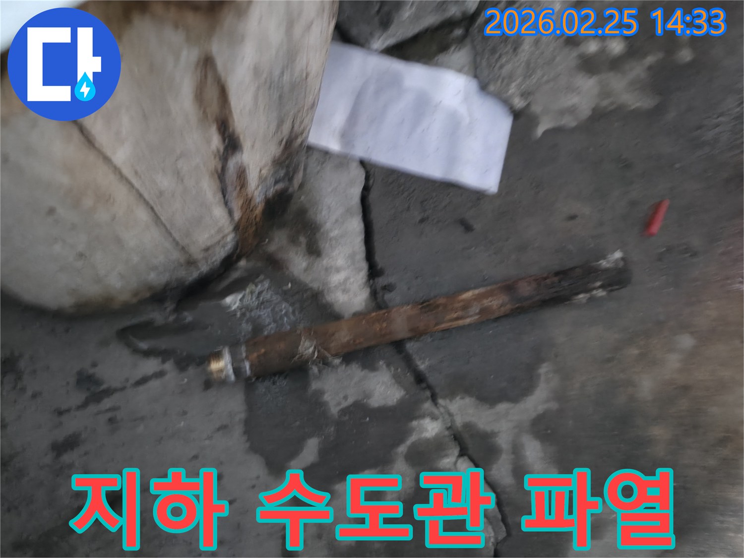 지하에 매설된-오래된 수도관이 파열되어-물이 새고 있는-긴급 누수 현장의 모습입니다.