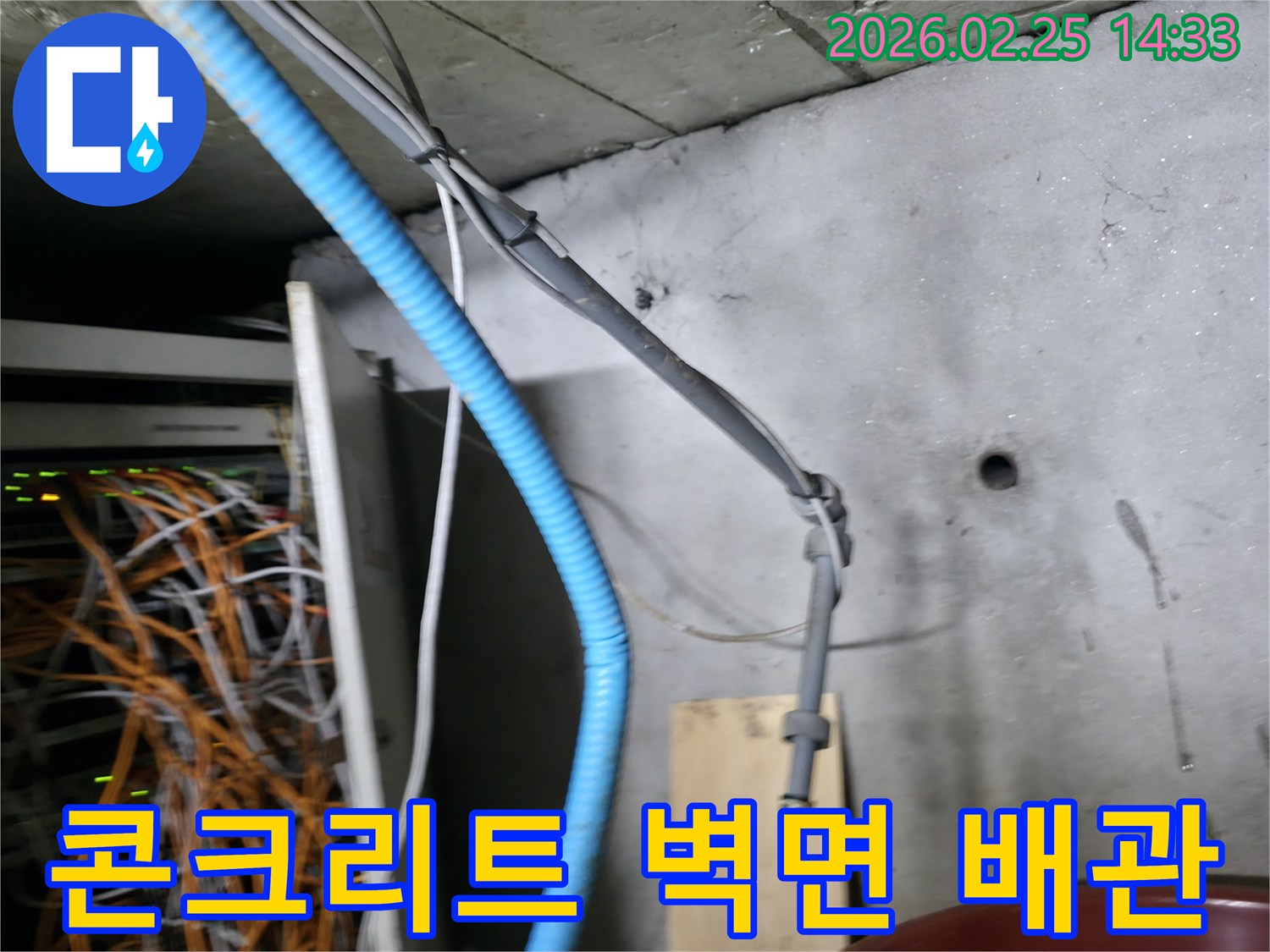 콘크리트 벽면에 고정된-파란색 주름관과 회색 케이블들이-누수 탐지 작업의-중요한 단서가 될 수 있습니다