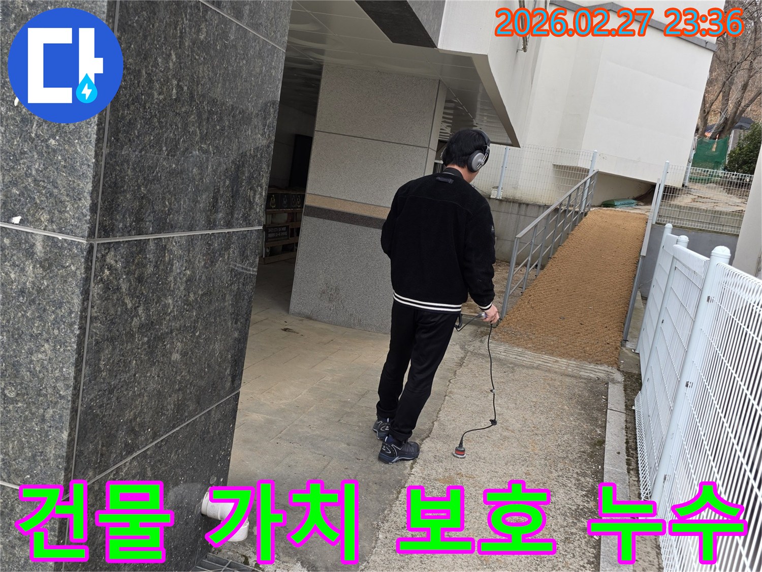누수 엔지니어가-청음식 탐지 장비로-빌라 외부의-누수 지점을 찾아내어-건물 가치 보호에 기여하는 모습