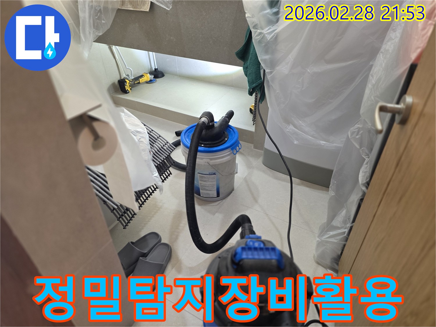 이 이미지는 누수 현장에서-주변을 비닐로 보양하고-강력한 습식 청소기와 조명 장비 등-정밀 탐지 장비의 위력을 보여주는 작업 현장입니다.
