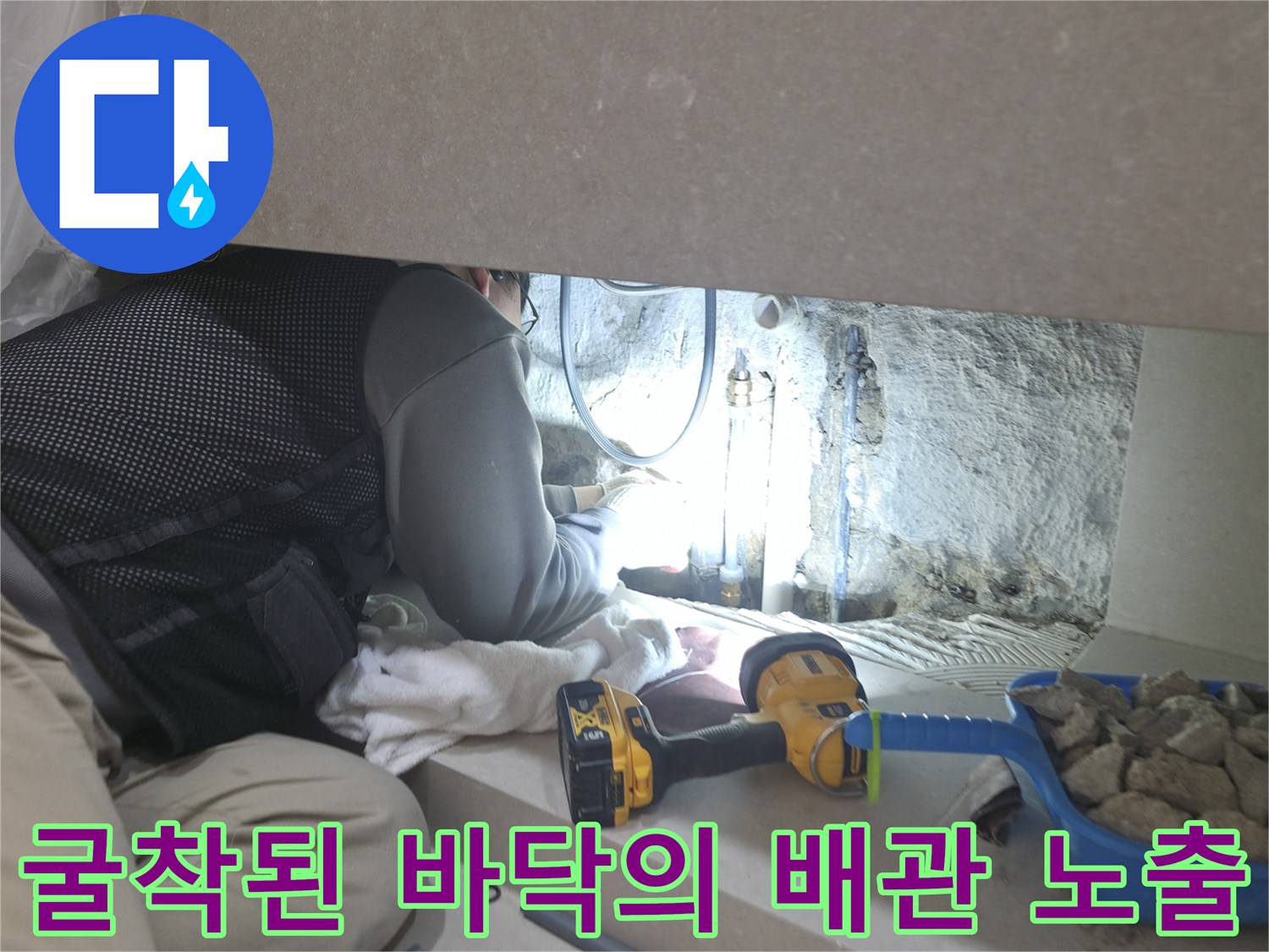 콘크리트 아래에서 발견된 누수 의심 배관 부위와 작업 도구