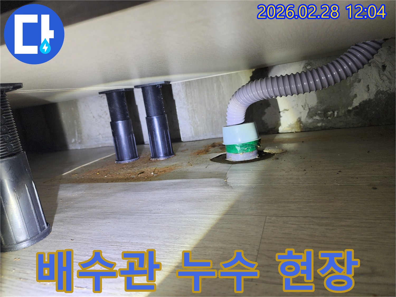 싱크대 배수관 연결부에서-발생한 누수로-바닥이 오염되고-젖어 있는 모습