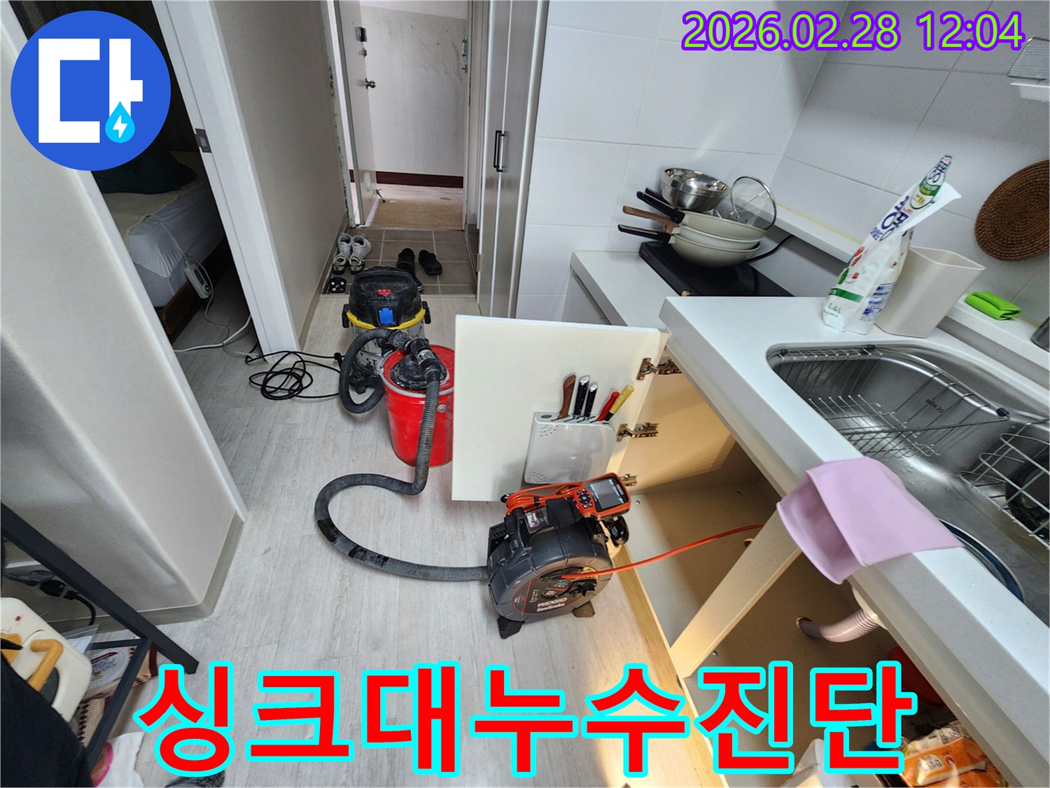 주방-싱크대-아래에서-발생한-누수를-정밀하게-진단하고-해결하기-위해-내시경-장비와-흡입기를-설치하는-모습
