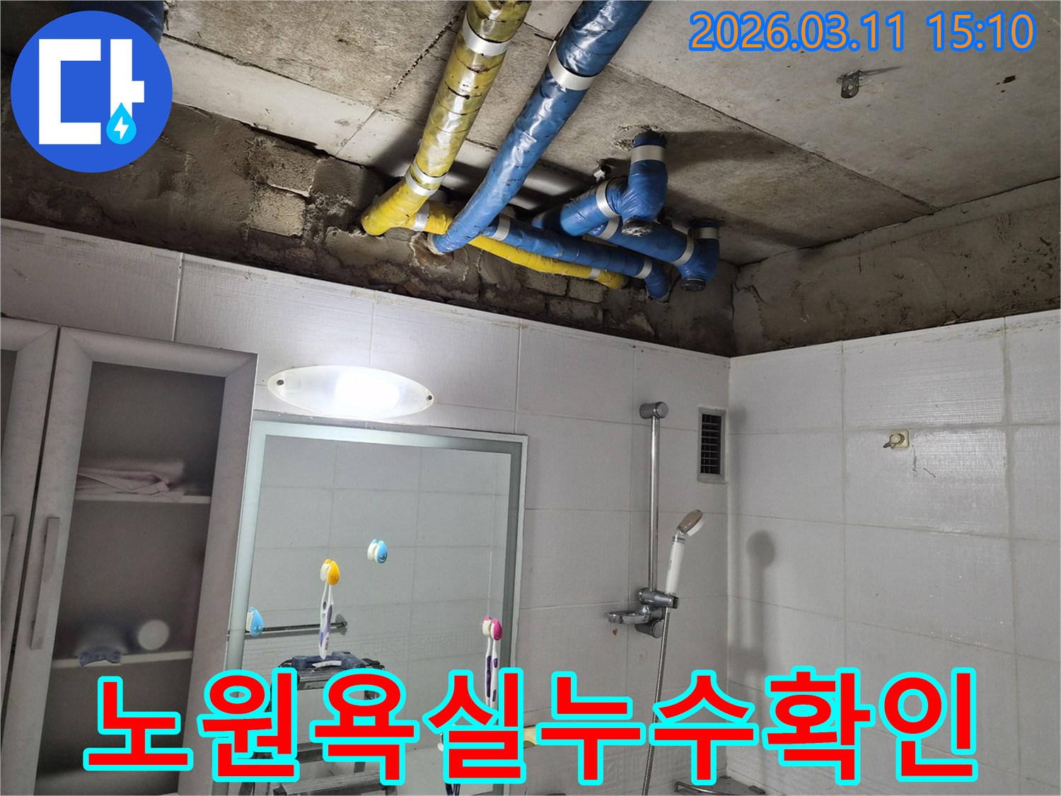 아파트-욕실 천장의-파란색과 노란색-단열 배관들이-노출된 채-누수 여부를-확인하는-장면입니다