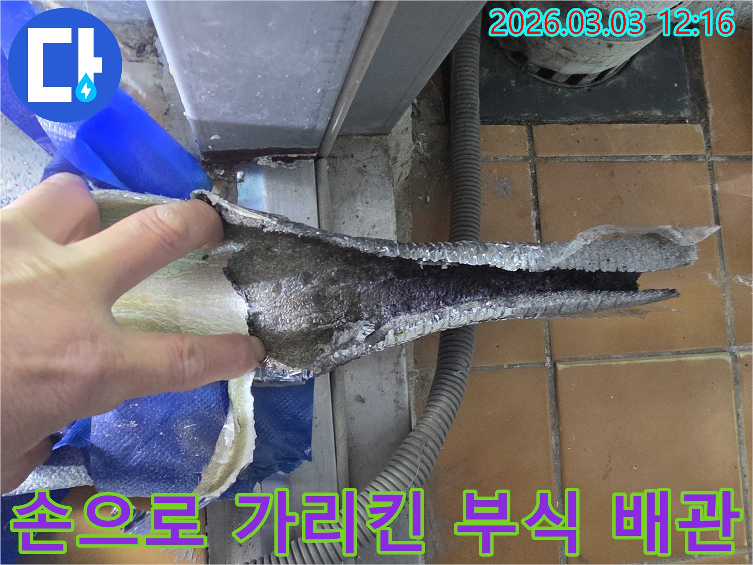 전문가가-손으로-가리키며-배관의-심각한-부식-상태를-설명하는-장면