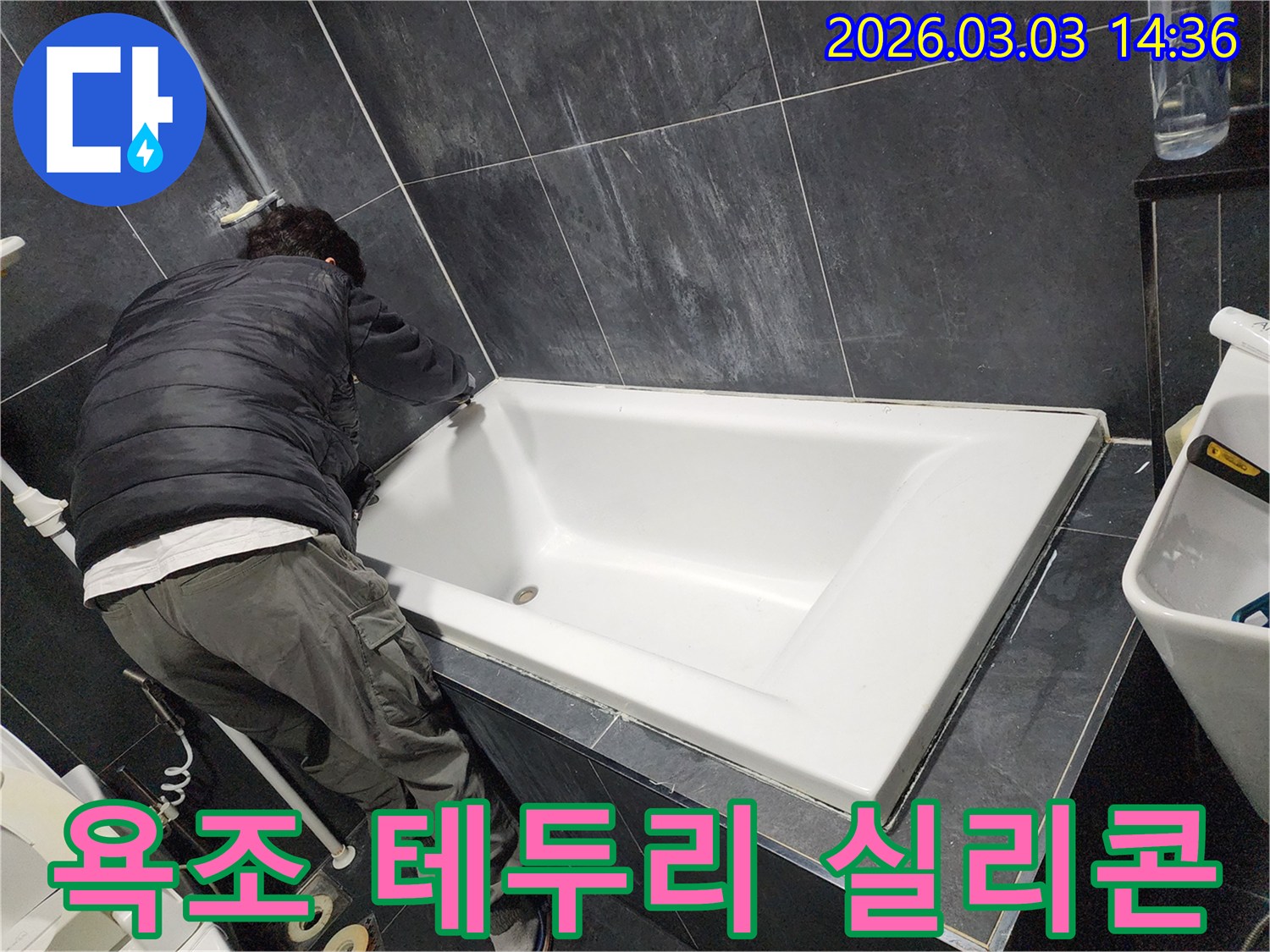 욕실 누수 문제를 해결하고-완벽한 마무리를 위해-전문가가 욕조 테두리에 방수 실리콘을 시공하는 모습입니다