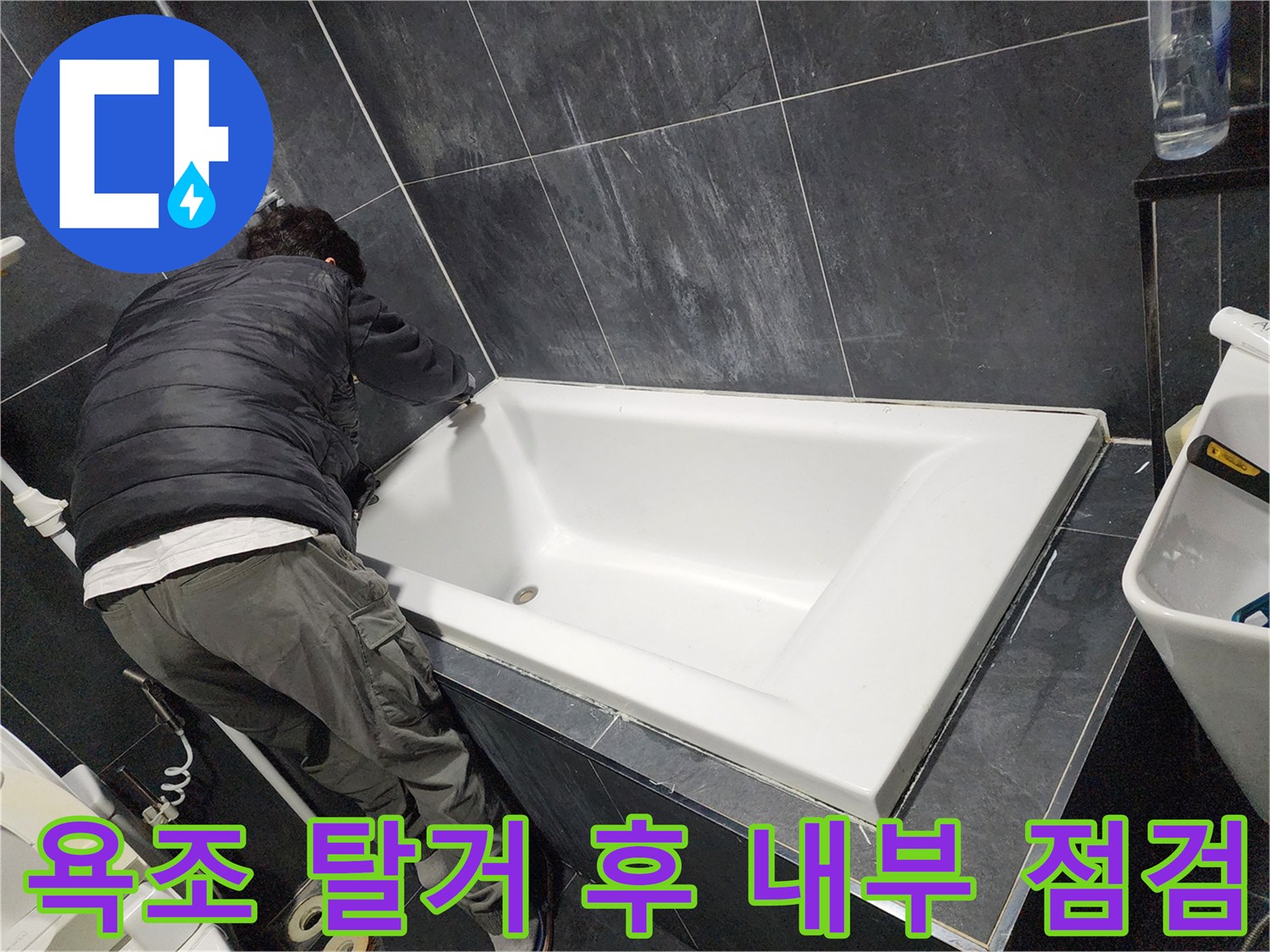 탈거된 욕조 아래 공간에서 진행되는 배관 점검 작업 상황
