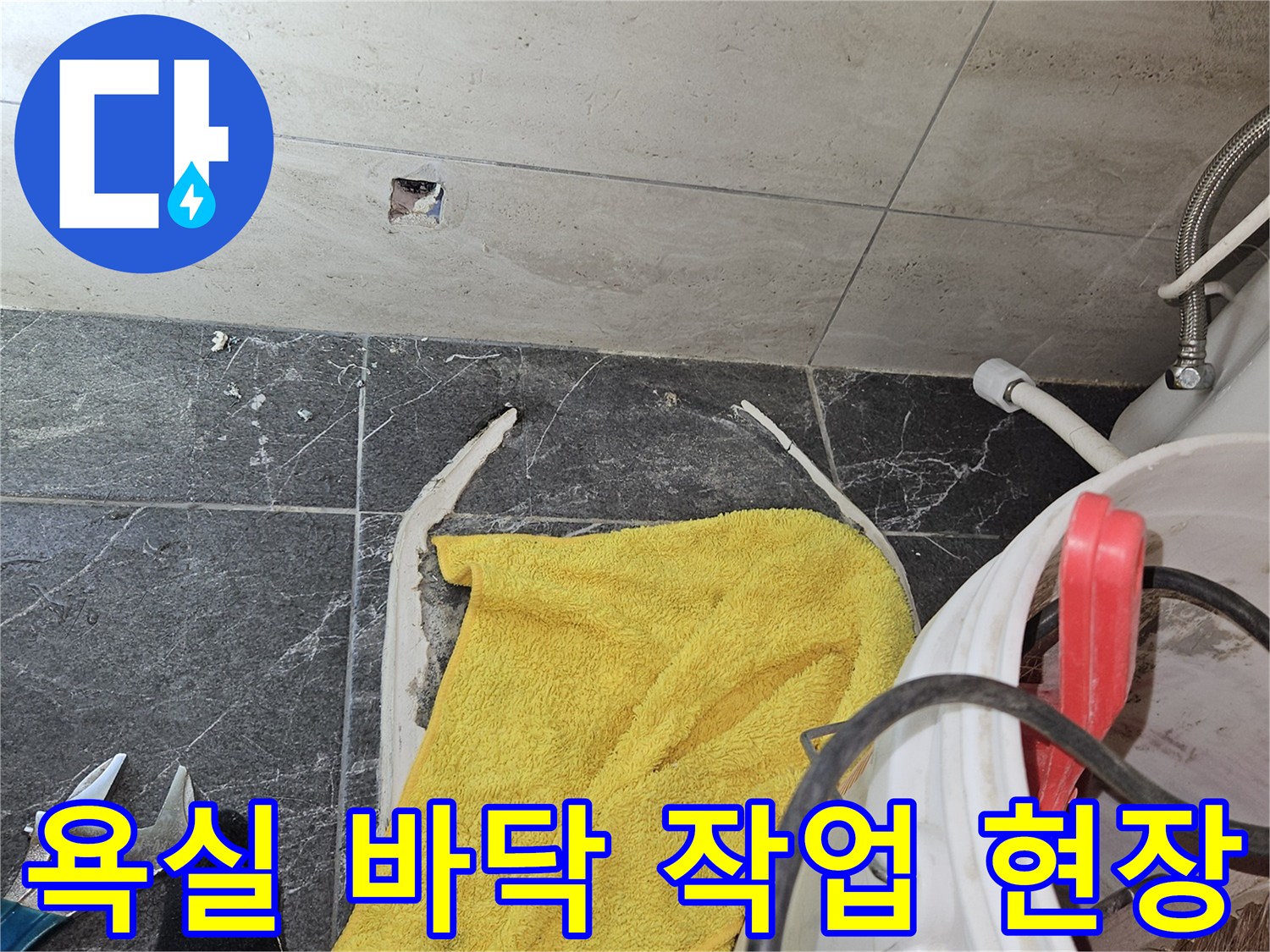 누수 점검을 위해 굴착된 화장실 타일 주변의 작업 도구와 양동이 모습
