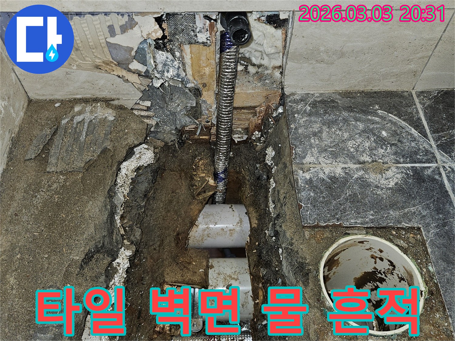 누수로 인해 타일이 손상되고-벽면 내부까지 물이 스며들어-오염된 흔적을 보여주는-작업 현장입니다