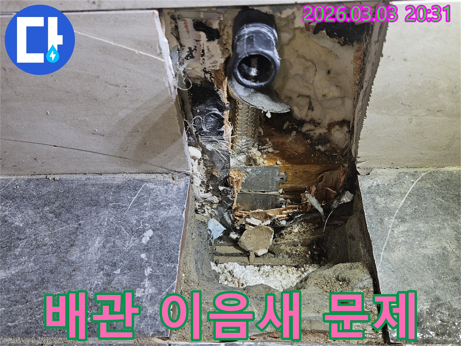 주택 벽면의 타일을 뜯어내고 누수 원인인 낡은 배관 이음새를 찾아낸 공사 진행 사진