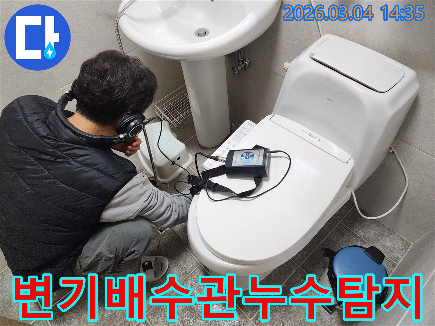 엔지니어가-헤드폰을-착용하고-변기-배수관-주변의-누수-여부를-청음식-탐지기로-정밀하게-진단하는-모습