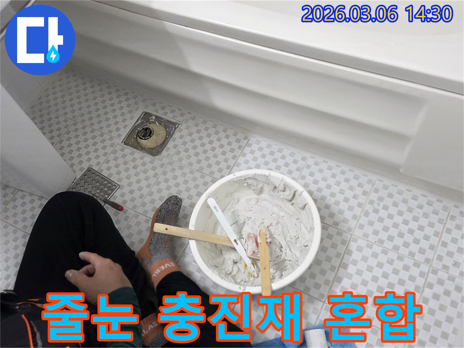 빌라 화장실 누수로 인한 타일 보수를 위해-작업자가 줄눈 충진재를 꼼꼼히 혼합하는 장면입니다