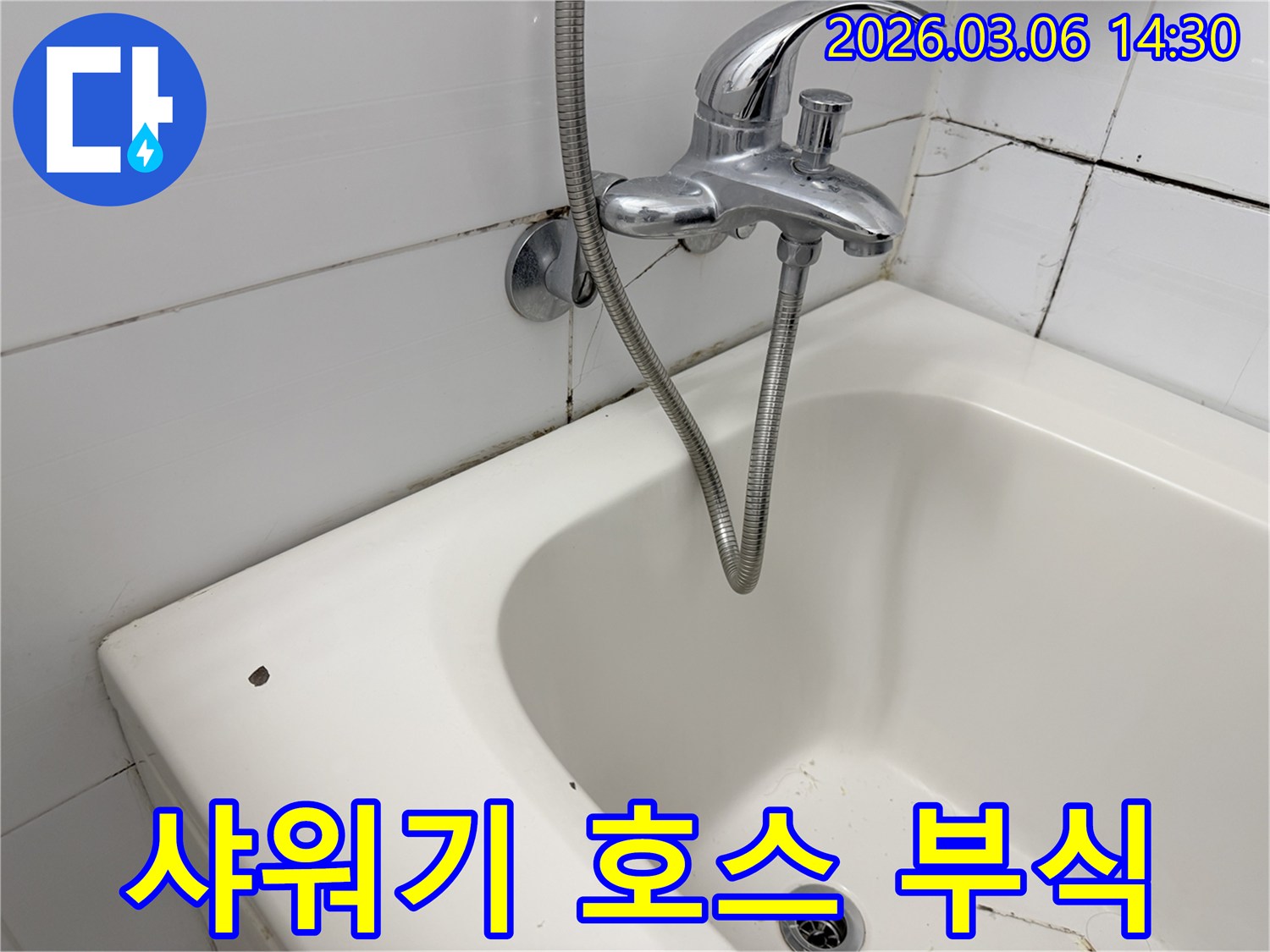 수도꼭지에 연결된-오래된 샤워기 호스와-주변의 부식 흔적이 보이는-욕실 현장입니다.
