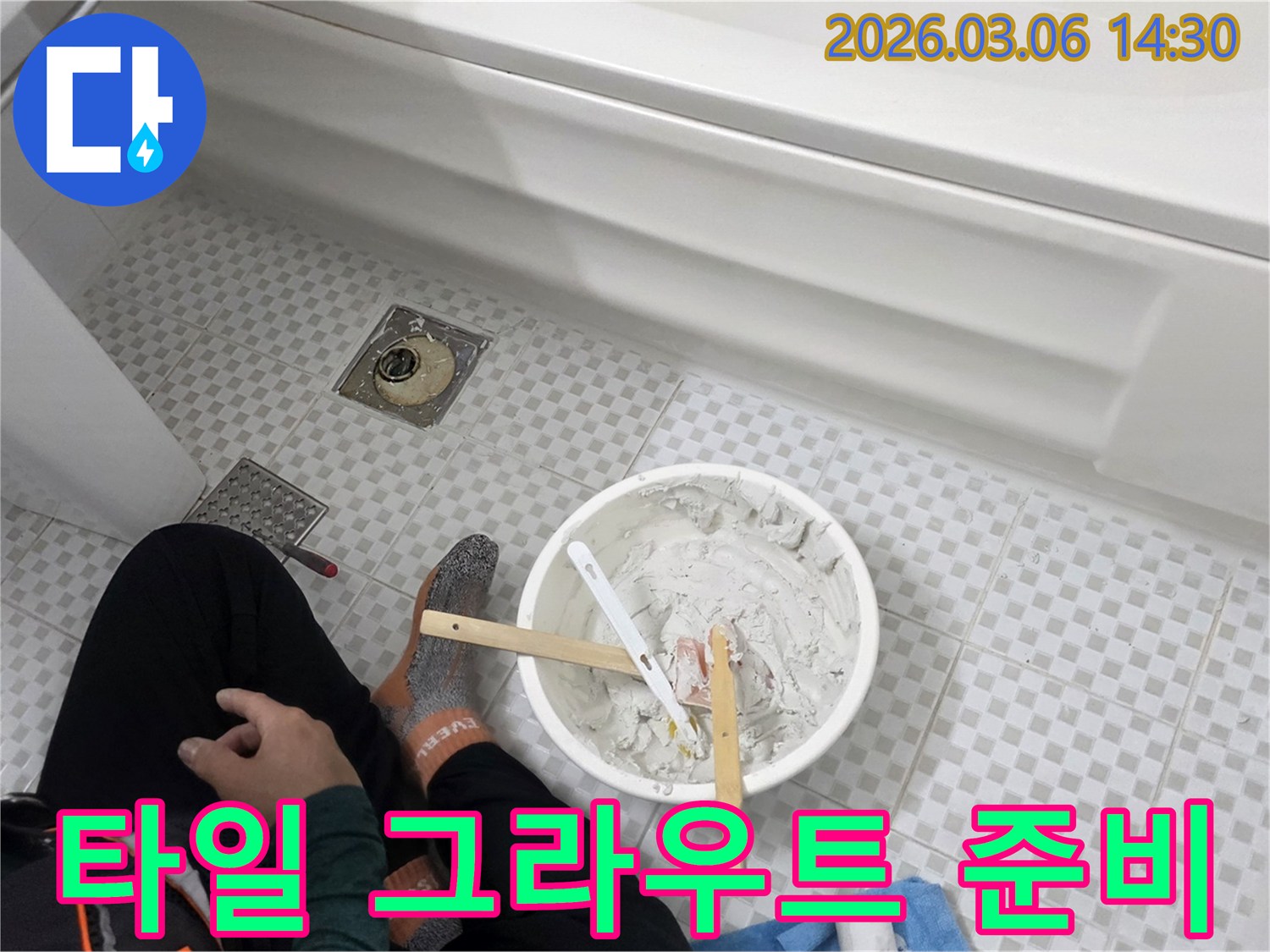 욕실 타일 누수를 막기 위해-작업자가 보수용 그라우트를 세심하게 준비하는 모습입니다