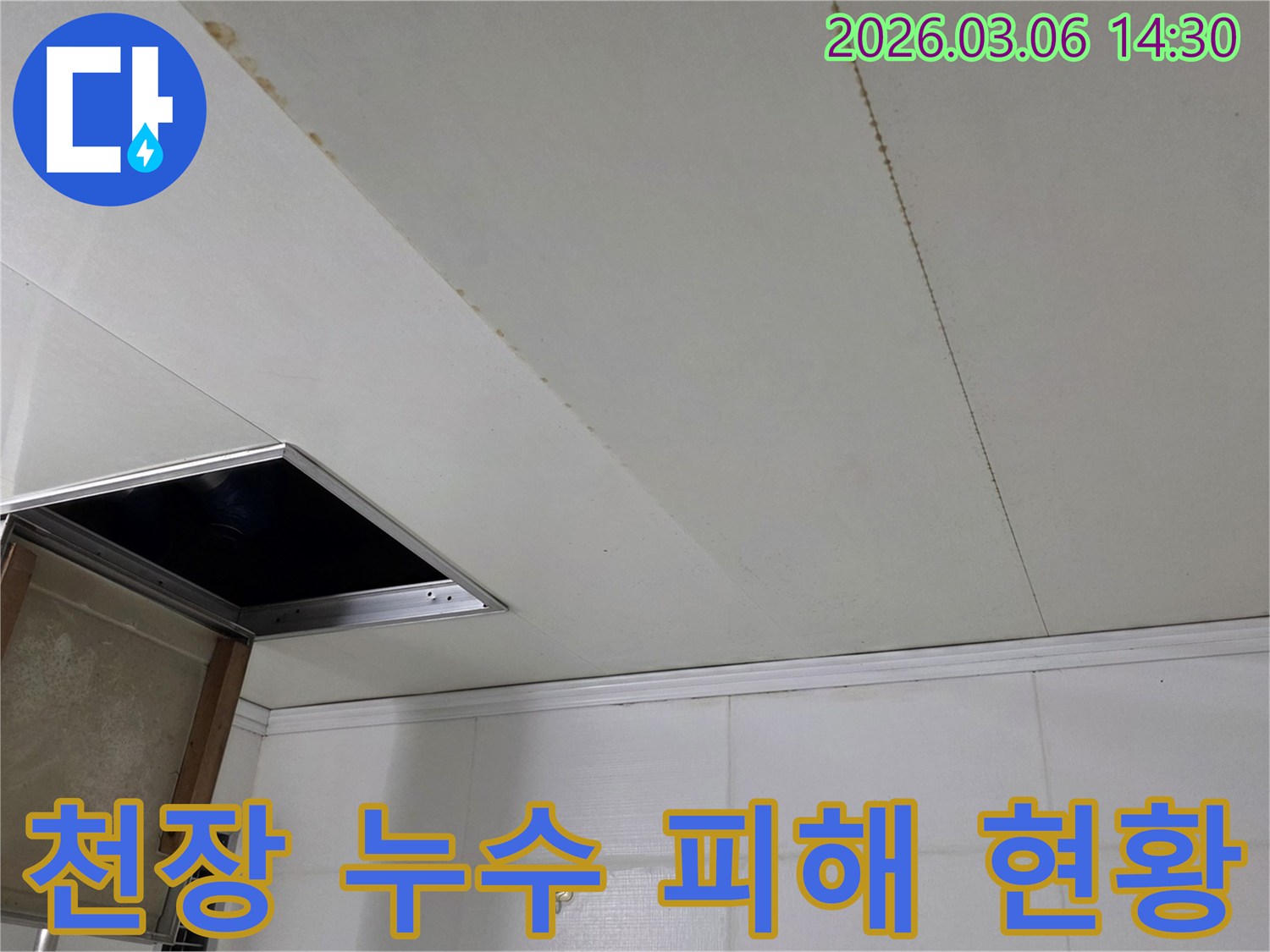 천장 마감재에 생긴 누수 흔적과-개방된 점검구를 보여주는 누수 현장 사진