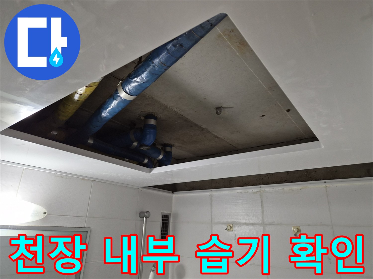 천장 점검구 내부에 보이는 파란색 보온 배관과 콘크리트 슬래브