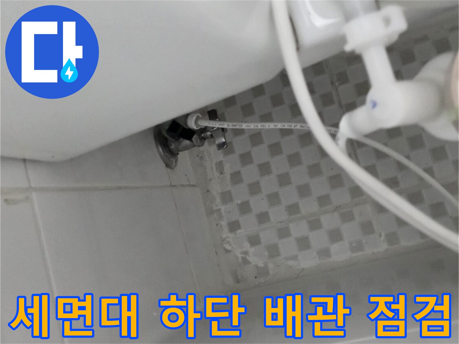 하얀색 세면대 아래쪽의 금속 및 플라스틱 배관 연결부