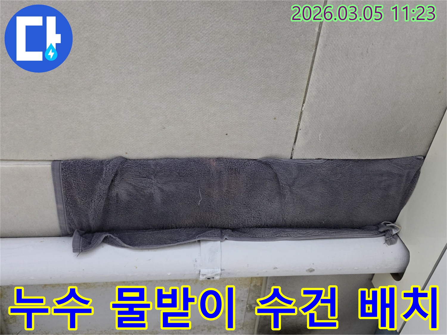 천장 타일 사이로 새는 물을-수건으로 임시적으로 막아둔 모습-누수 발생 시 초기 대응의 중요성