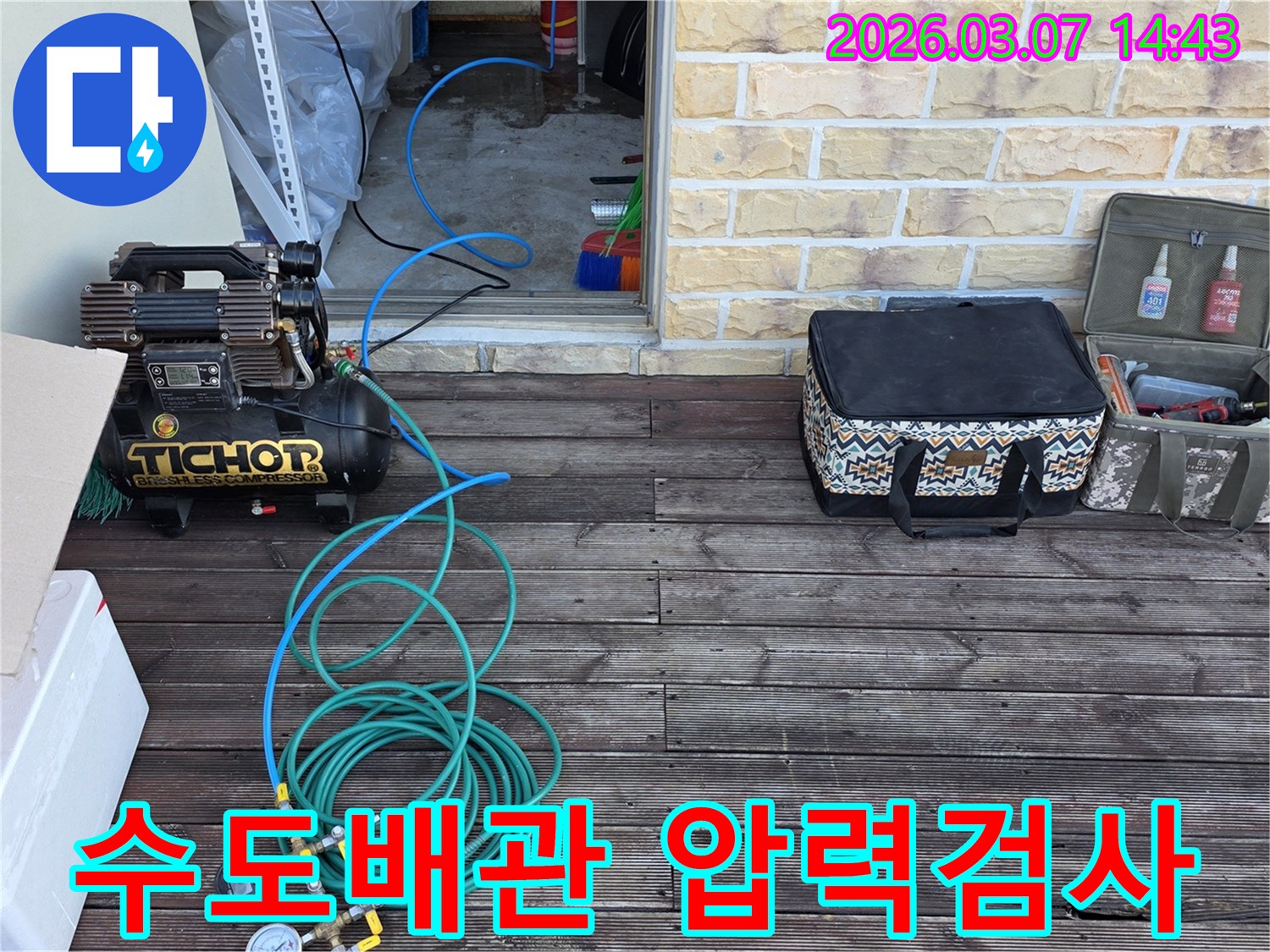 수도배관의 누수 여부를 확인하기 위해-압력 게이지와 호스를 연결하여-정밀 검사를 준비하는 장면