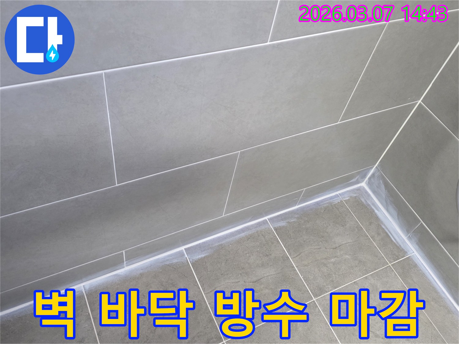 회색 타일로 된-아파트 욕실의-벽과 바닥 경계면을-새로운 실리콘으로-튼튼하게 마감하여-누수를 방지한 사진