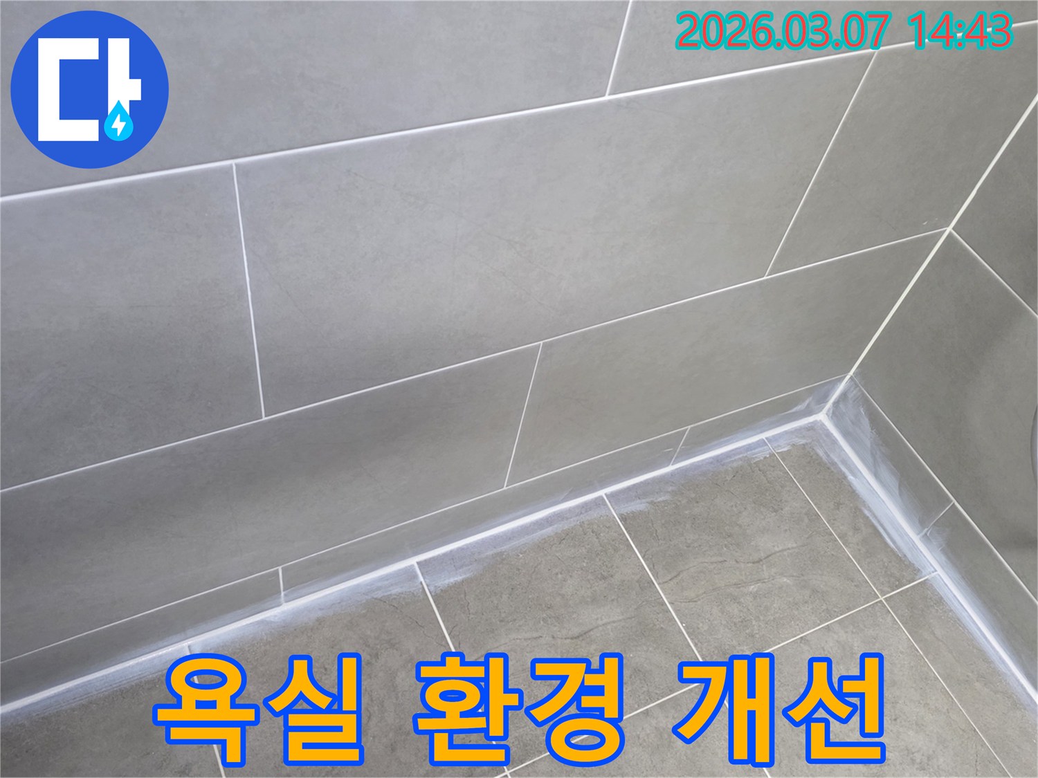 회색 타일로 된-욕실 벽과 바닥의-경계면이-새로운 실리콘으로-깔끔하게 마감되어-쾌적한 환경을 조성한 사진