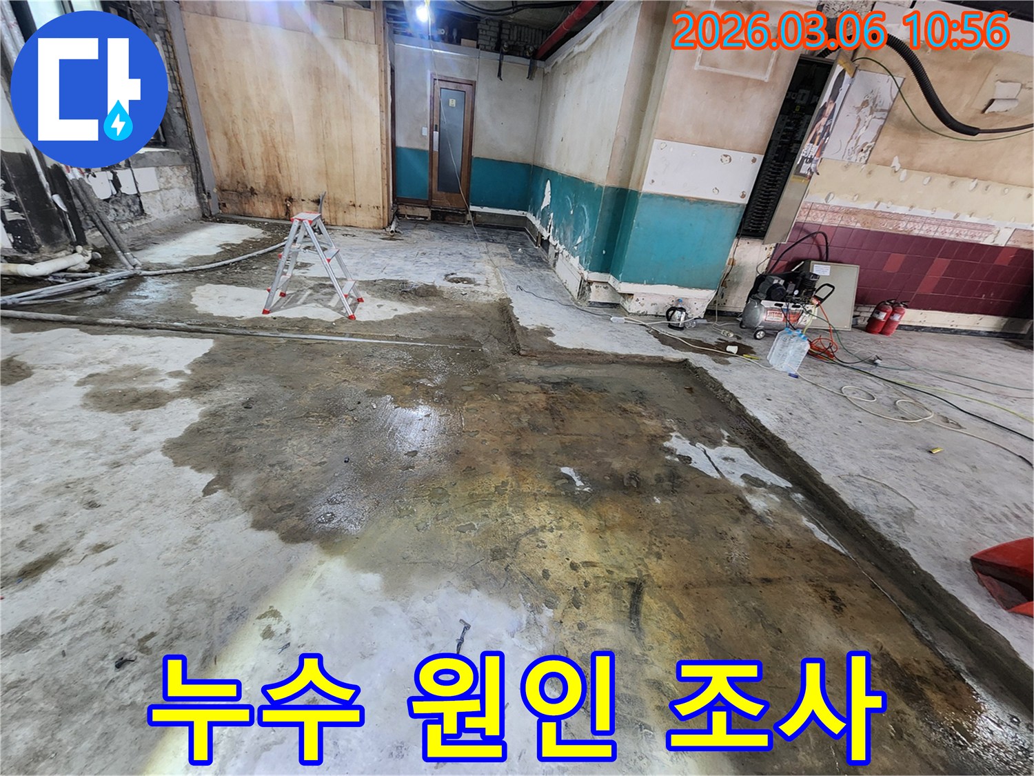 누수 공사 현장에서-바닥을 철거하고-물이 고인 모습을 보여줍니다.