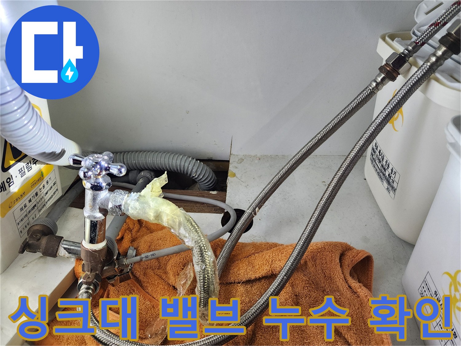 싱크대 하단 앵글밸브와 고압 호스 연결 부위의 누수 상태를 보여주는 사진입니다.