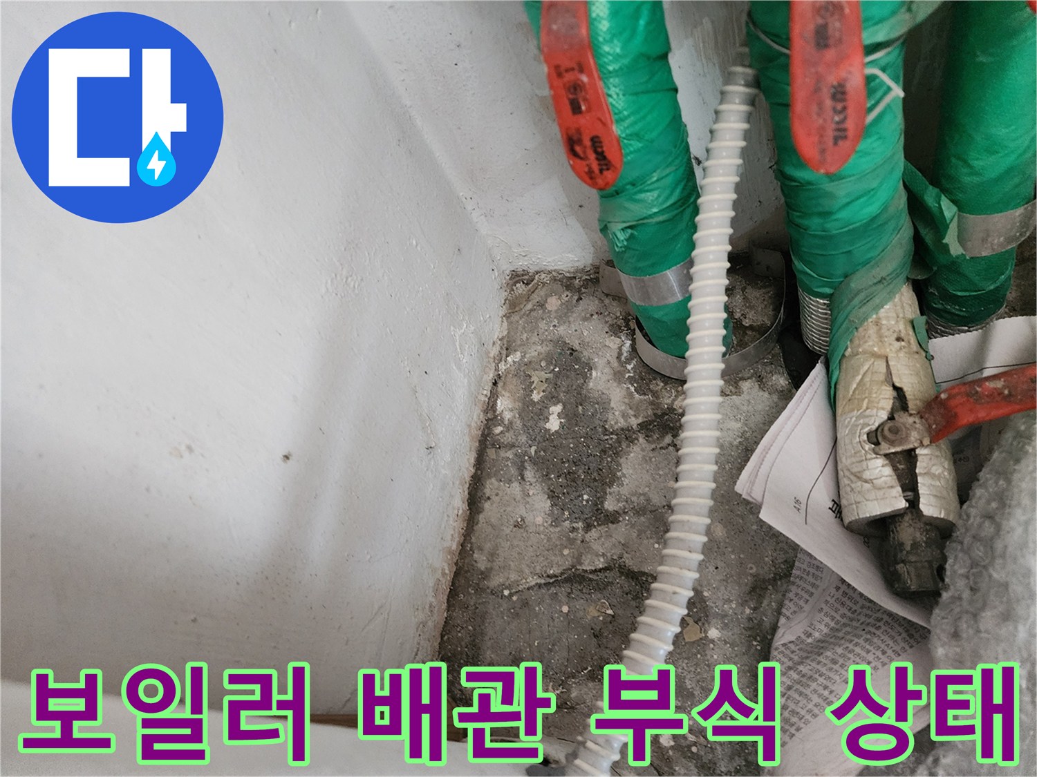 초록색 보온재로 감싸진-보일러 배관의 연결 부위와 노후된 상태를 보여주는 사진입니다.