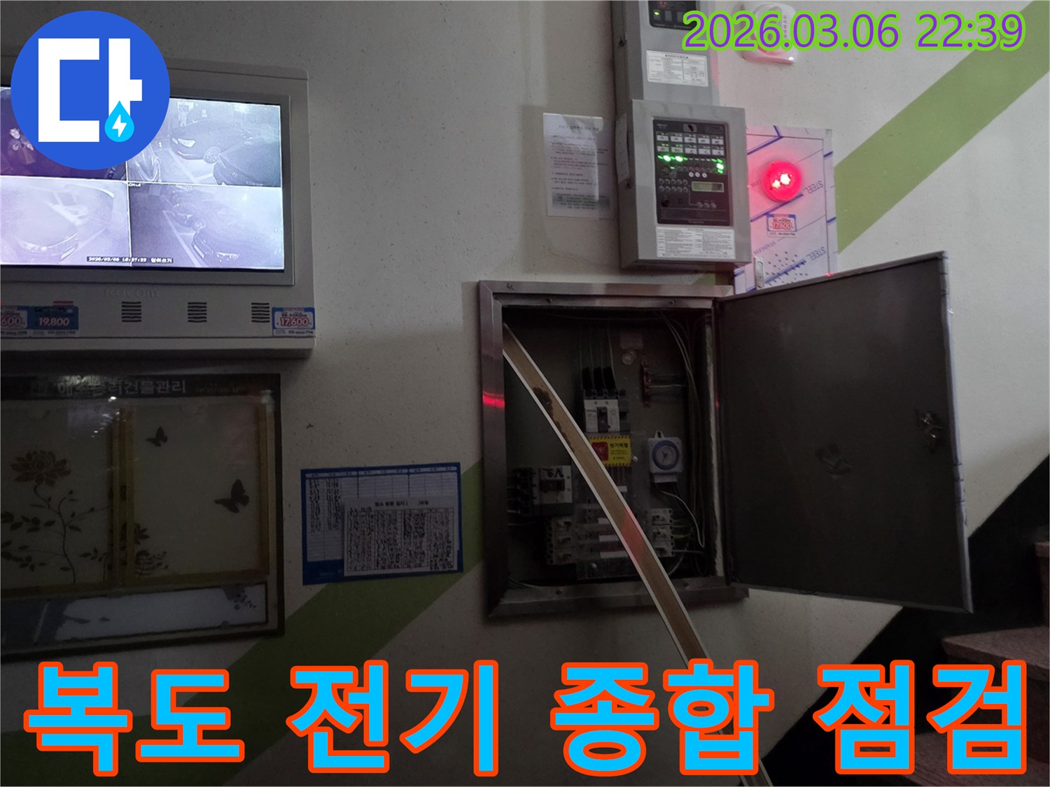 건물 복도에서 발생한 누수로 인해-전기 시설물 전체를-종합적으로 점검하는 전문가의 모습입니다.