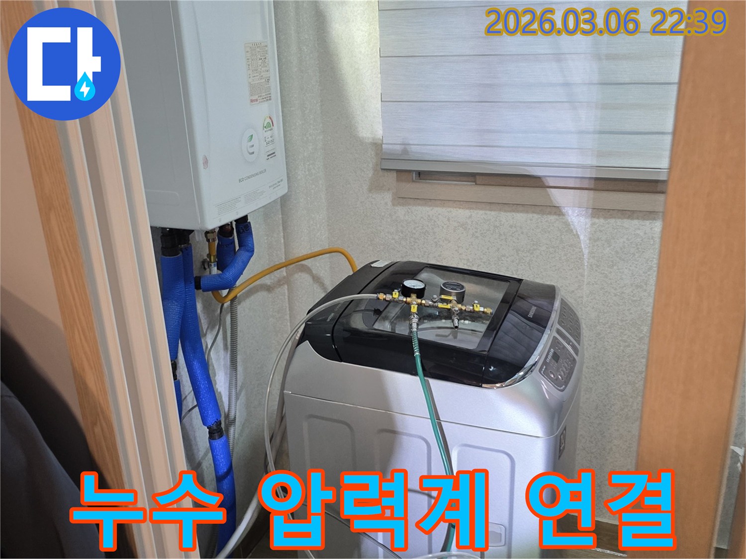 수도관-누수-여부를-확인하기-위해-세탁기-옆-배관에-압력-측정-장비를-설치하고-있는-사진